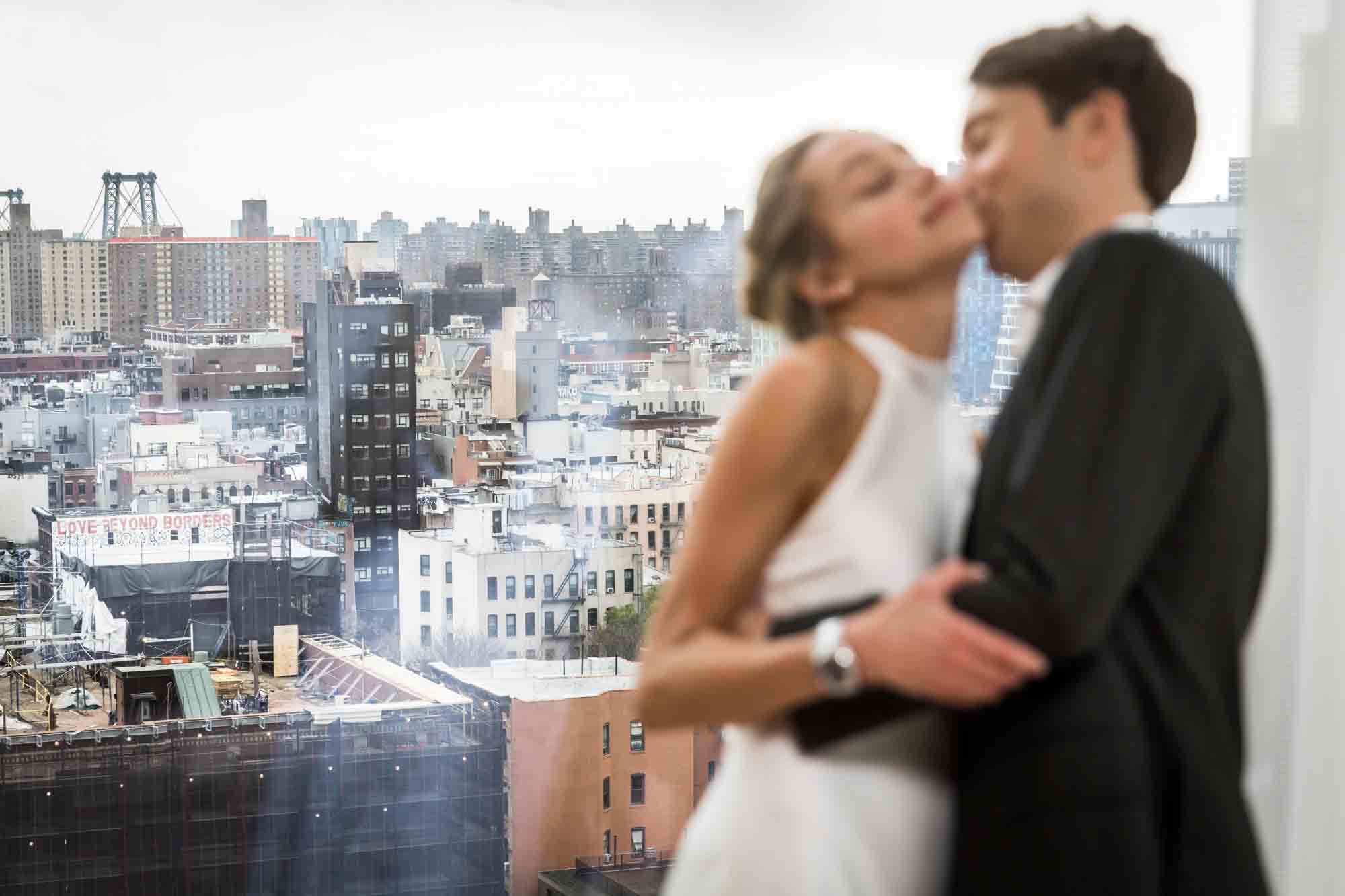 View of Lower East Side in New York City with couple kissing in foreground