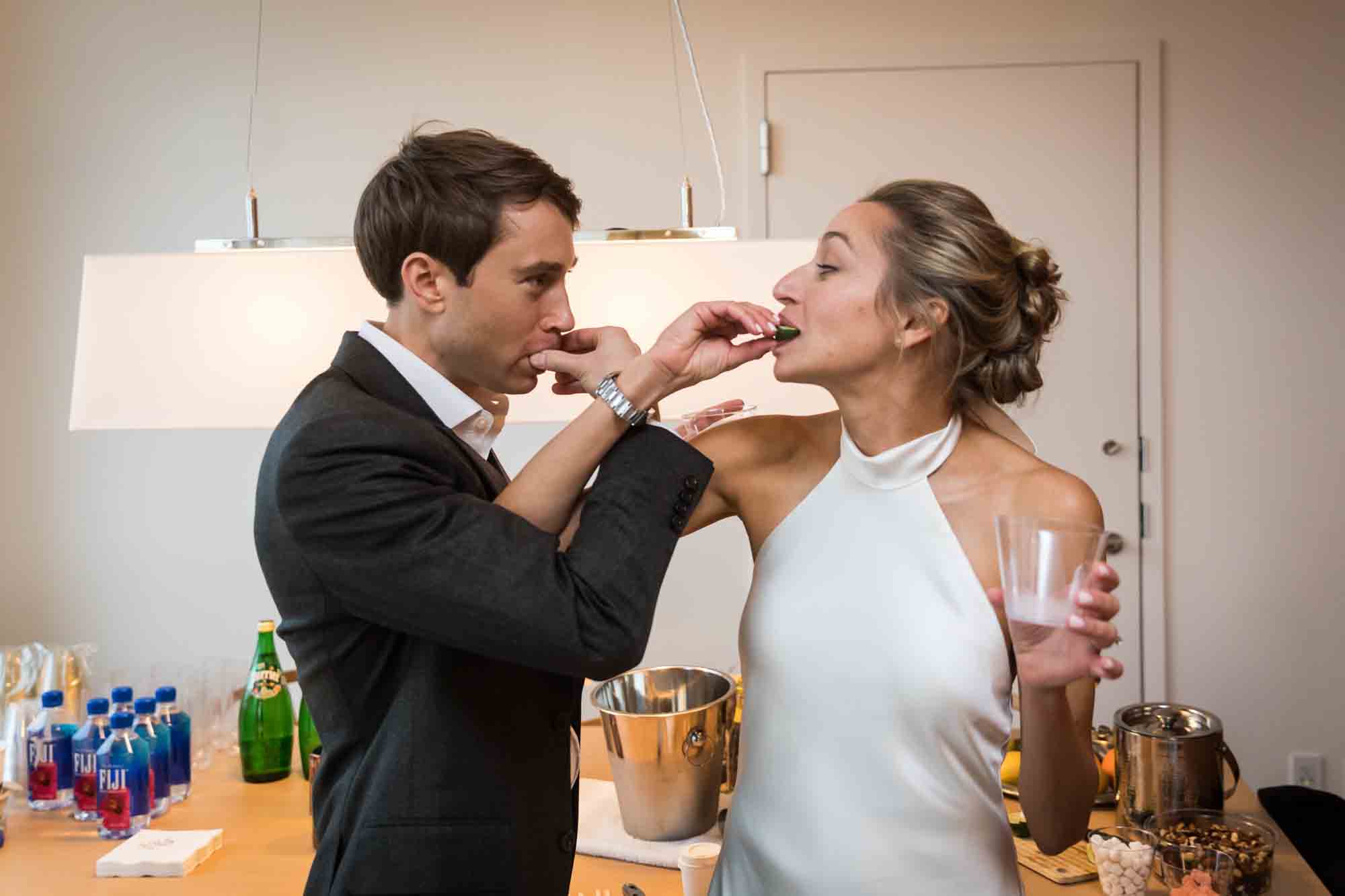 Bride and groom feeding each other a lime for an article on how to plan a hotel room wedding ceremony