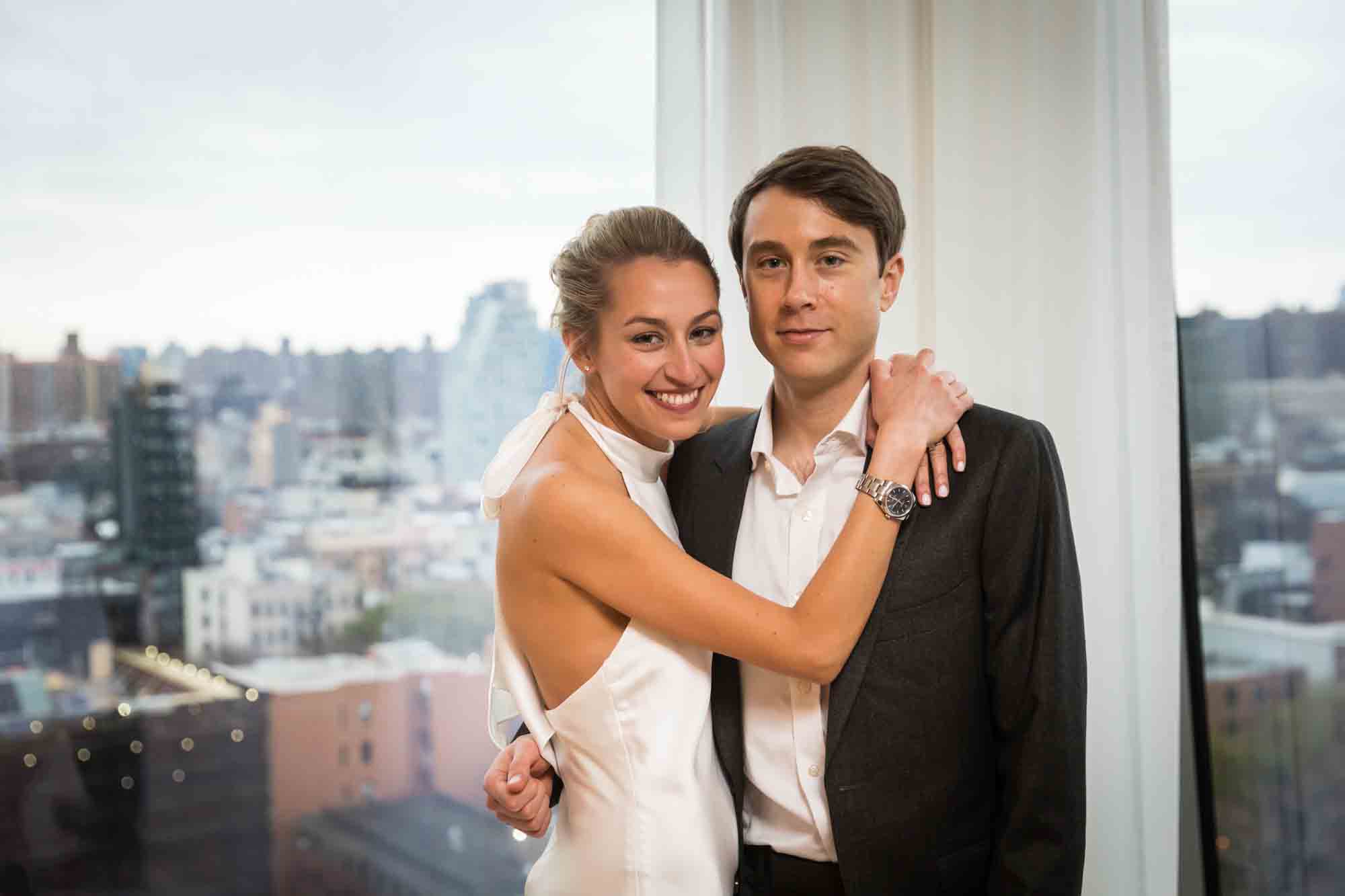 Couple hugging in front of window at a Public Hotel wedding