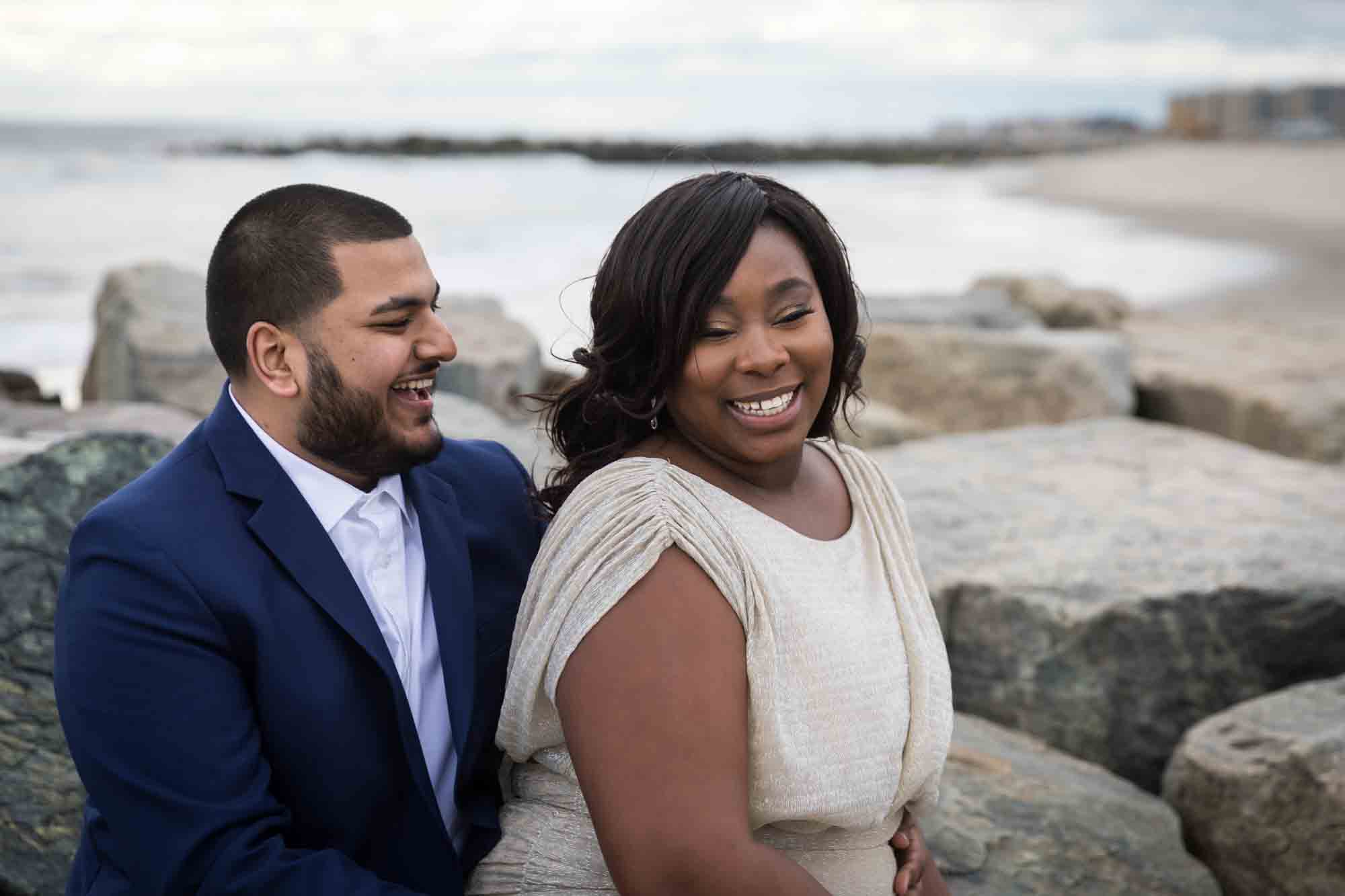 Couple laughing with rock jetty in the background