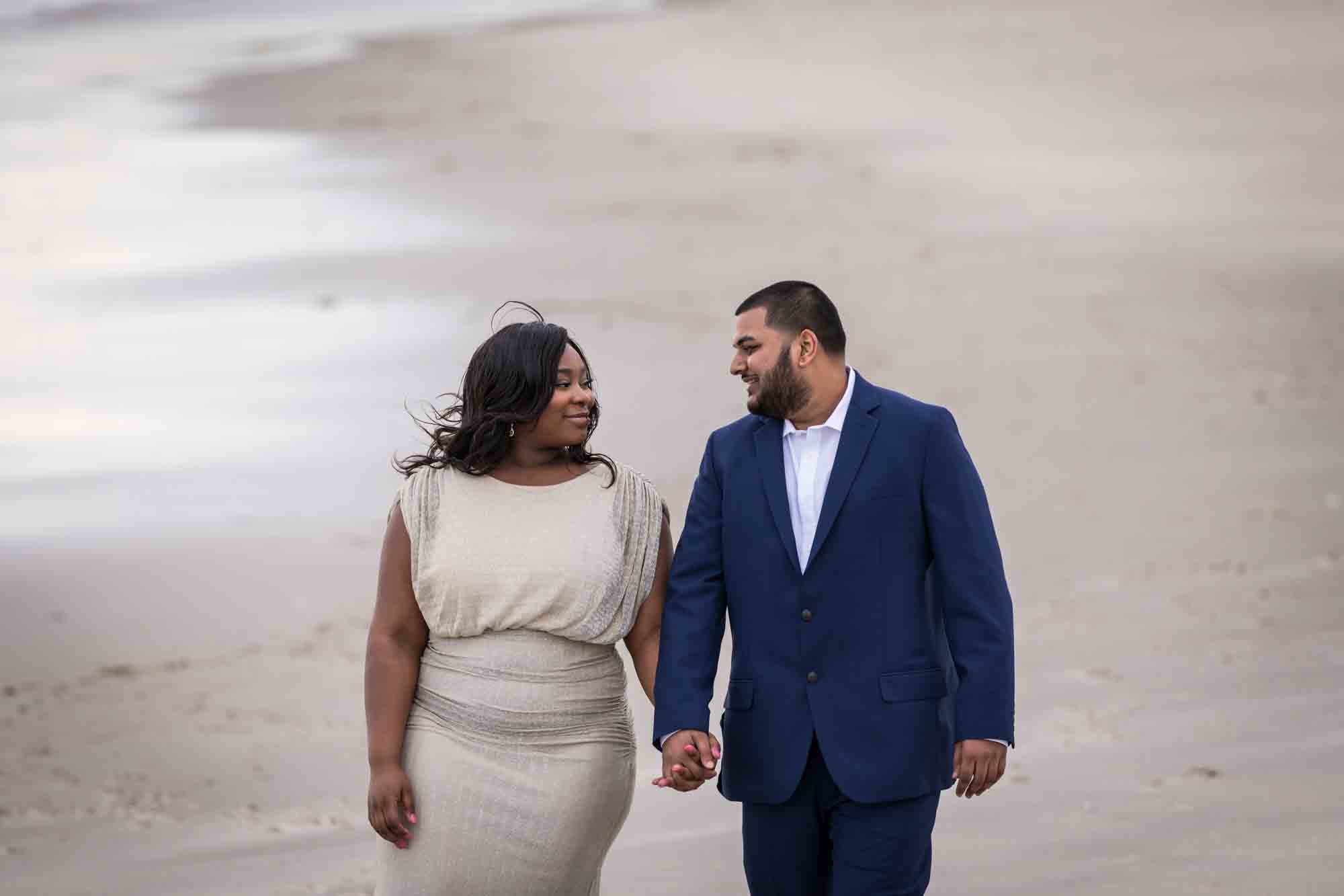 Couple holding hands and walking on beach