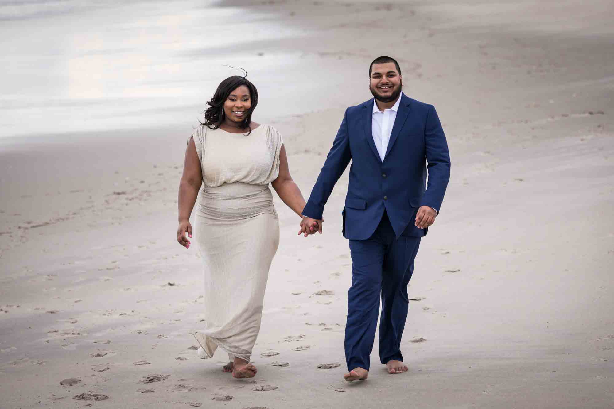 Couple holding hands and walking on beach