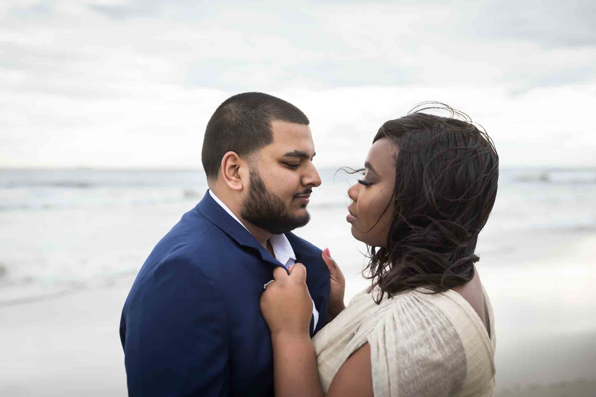 Woman pulling man towards her on beach