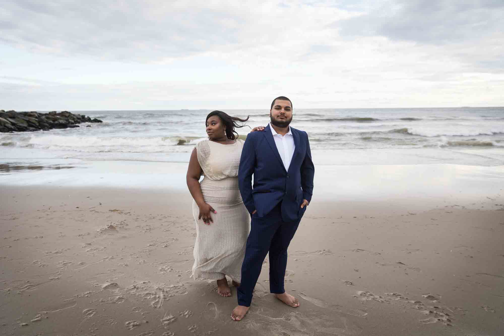 Couple standing in front of waves and jetty