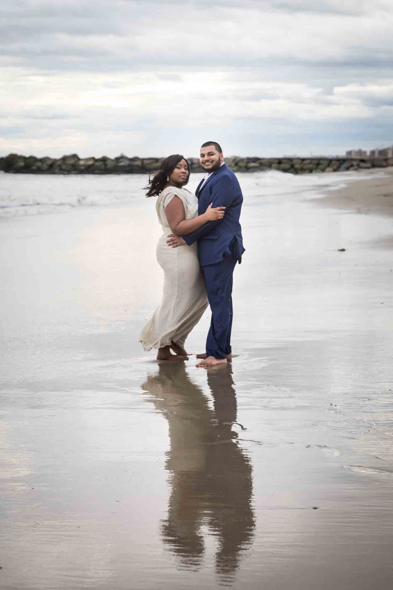 Couple reflected on beach for an article on how to plan the perfect beach engagement photo shoot