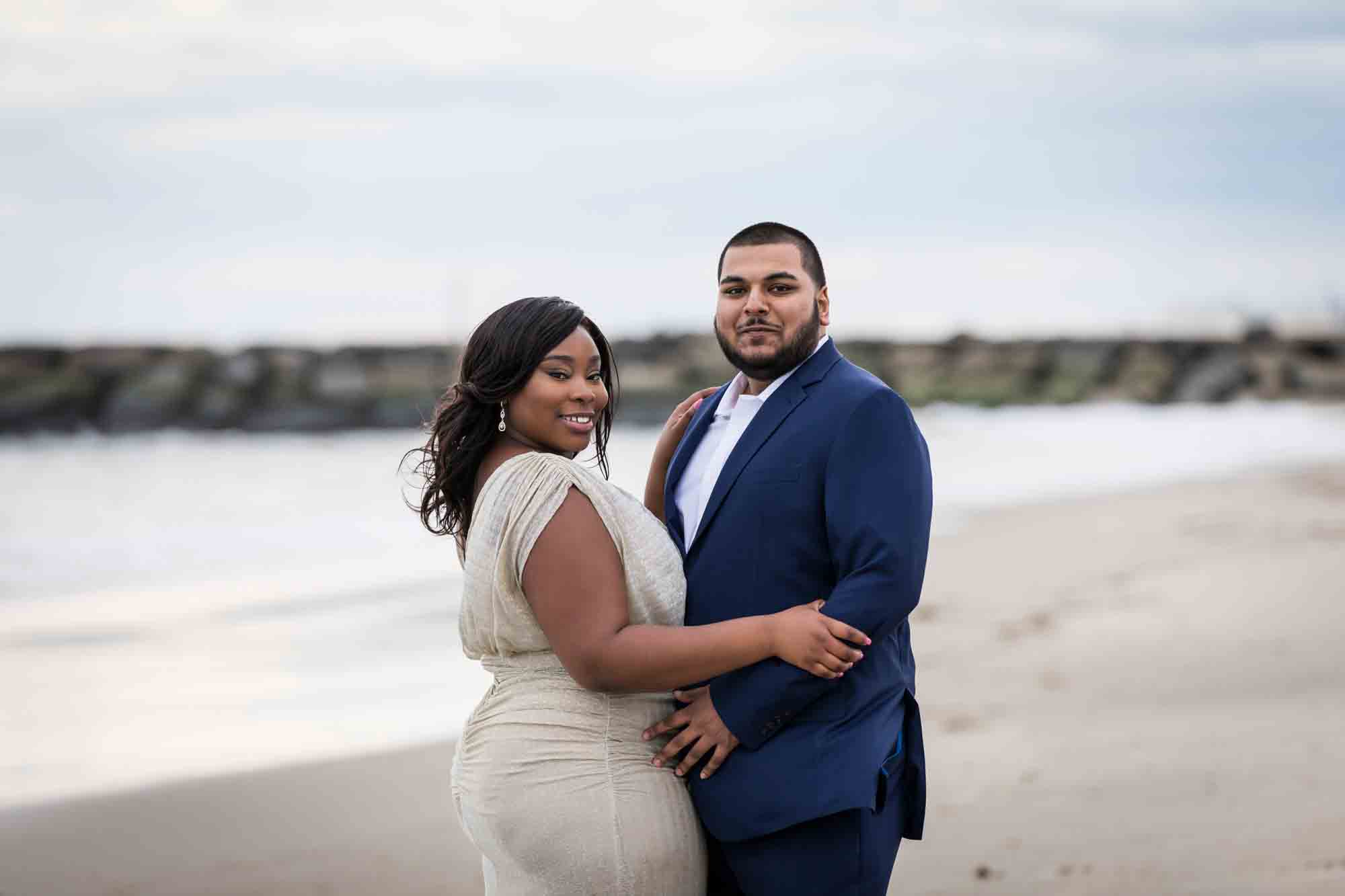 Couple hugging on beach for an article on how to plan the perfect beach engagement photo shoot