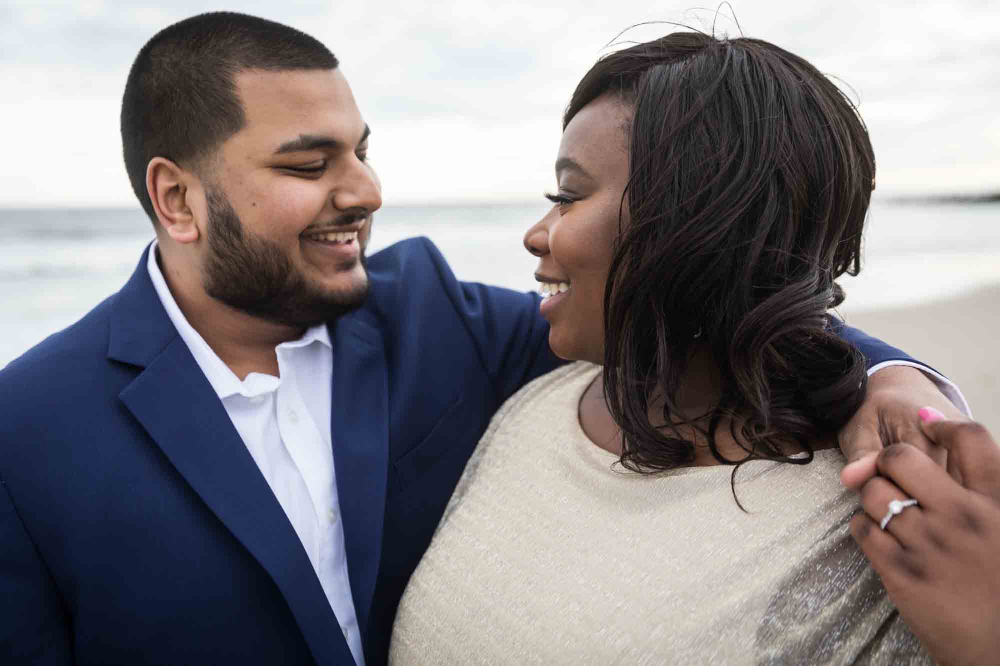 Couple smiling at each other for an article on how to plan the perfect beach engagement photo shoot