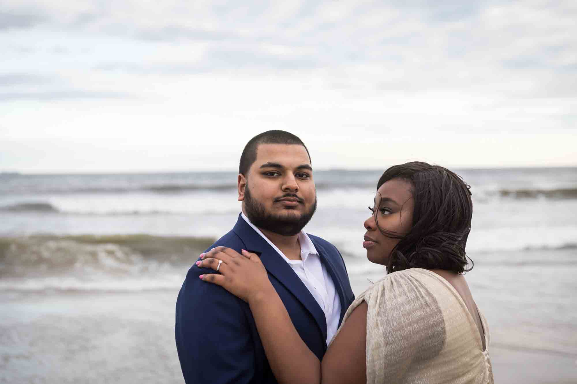 Couple in front of waves for an article on how to plan the perfect beach engagement photo shoot