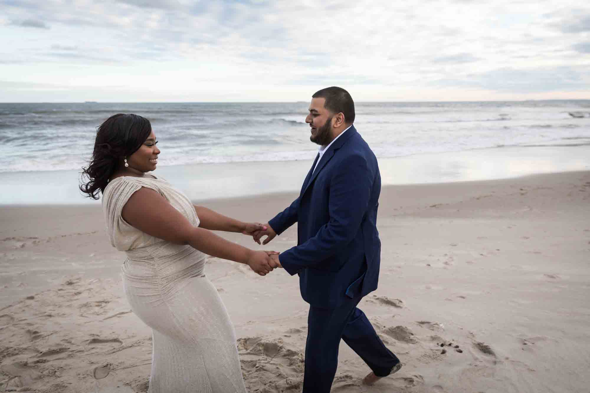 Couple dancing on the beach for an article on how to plan the perfect beach engagement photo shoot