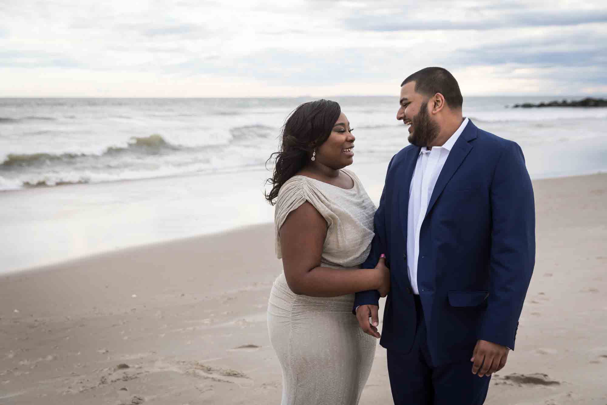 Couple looking at each other for an article on how to plan the perfect beach engagement photo shoot