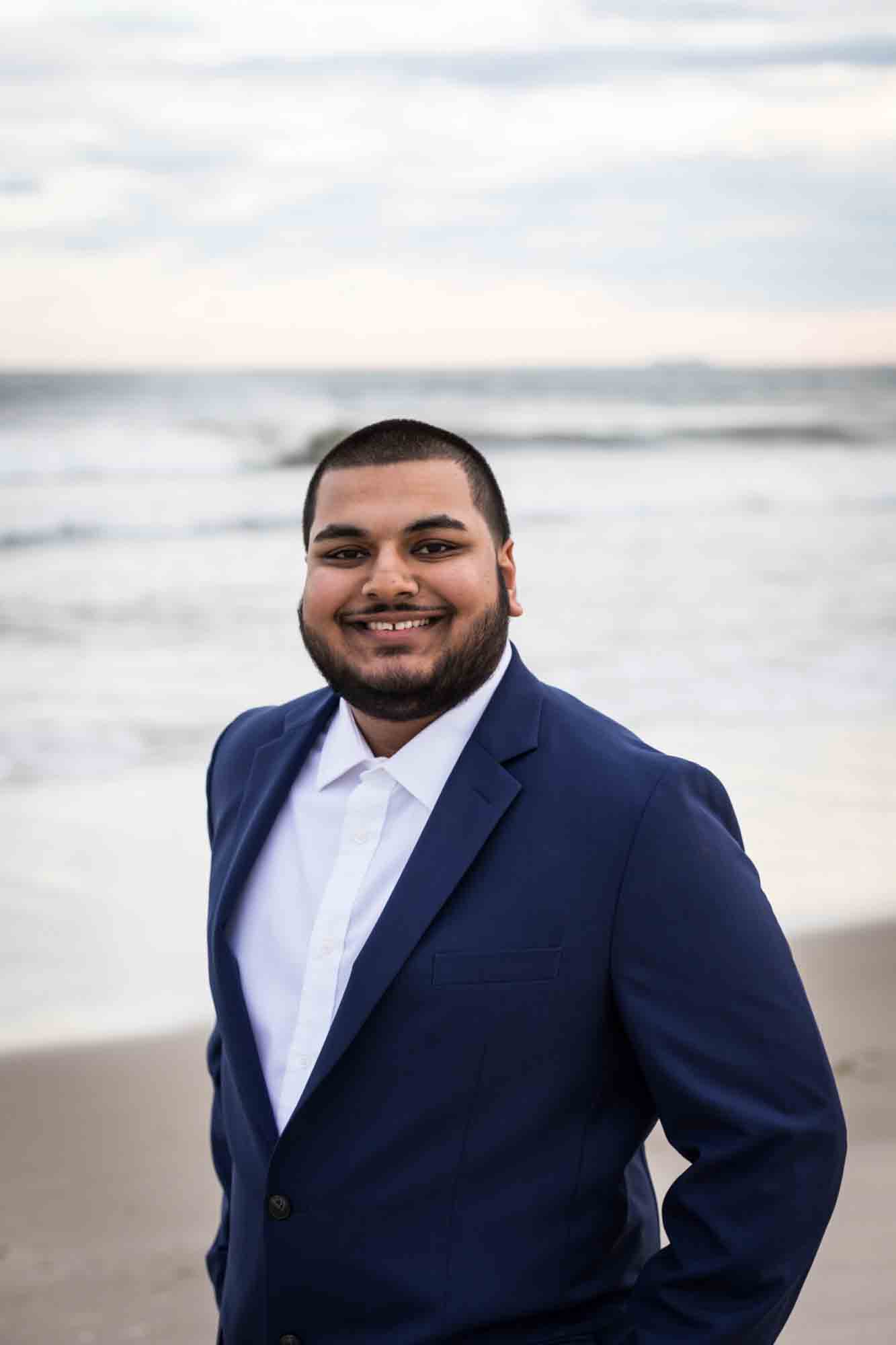 Man wearing blue blazer in front of waves