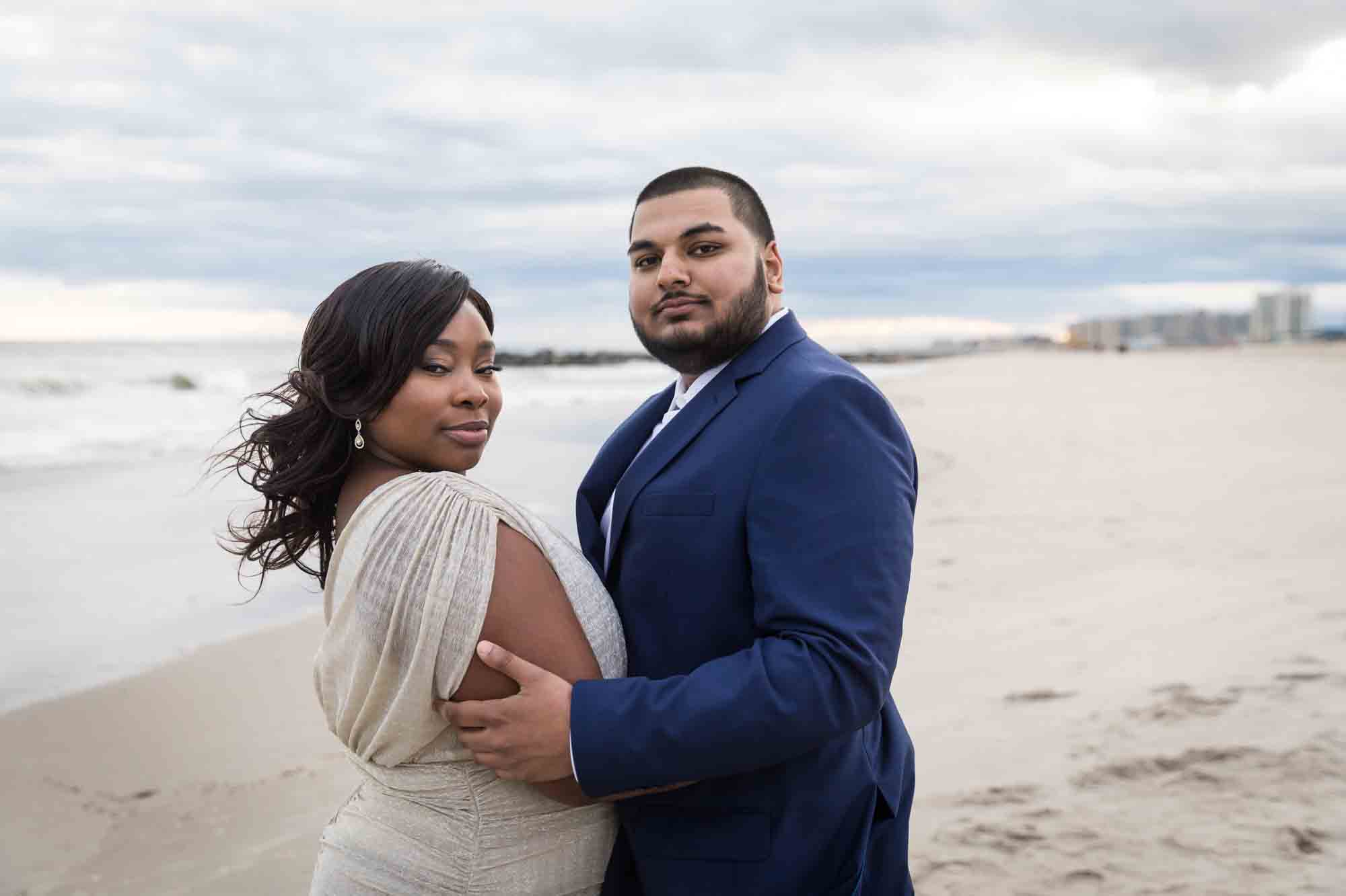 Couple embracing on the beach for an article on how to plan the perfect beach engagement photo shoot