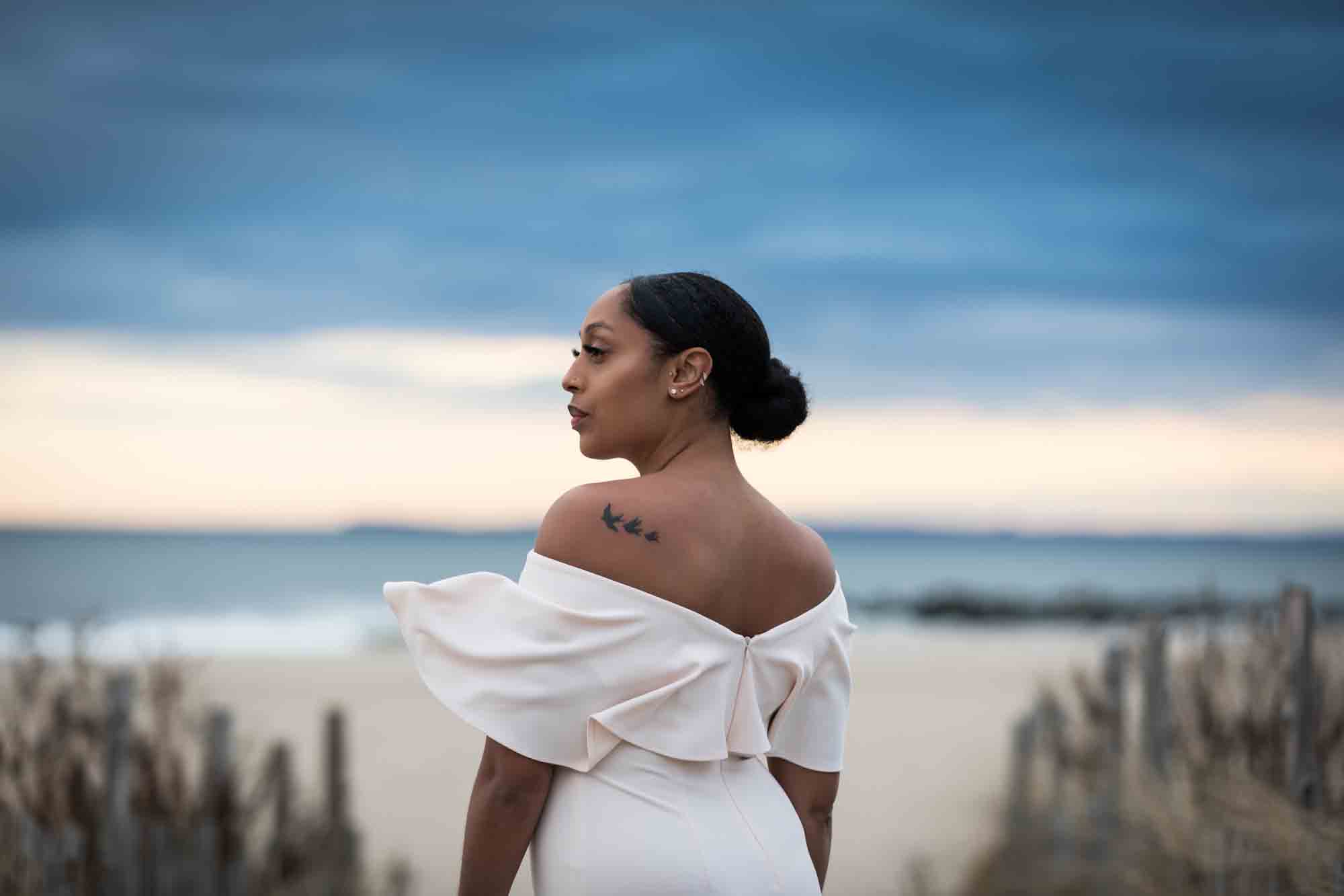 Woman wearing off shoulder dress with tattoo on shoulder