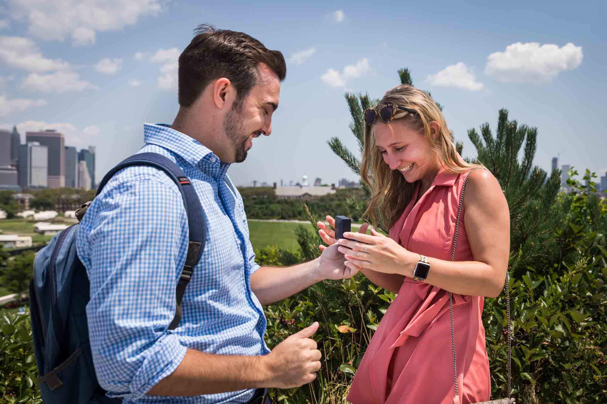 Man handing engagement ring to woman for an article on how to propose on Governors Island