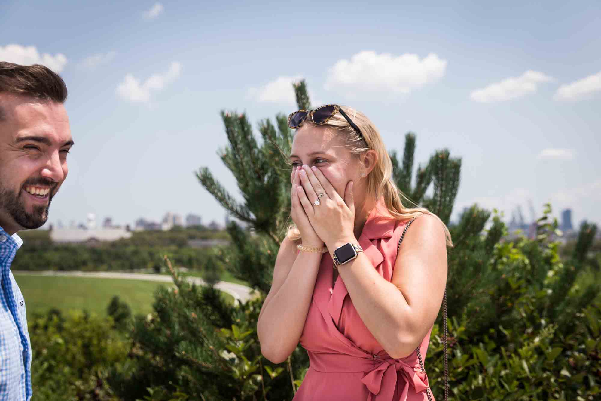 Woman with hands covering her face after proposal for an article on how to propose on Governors Island