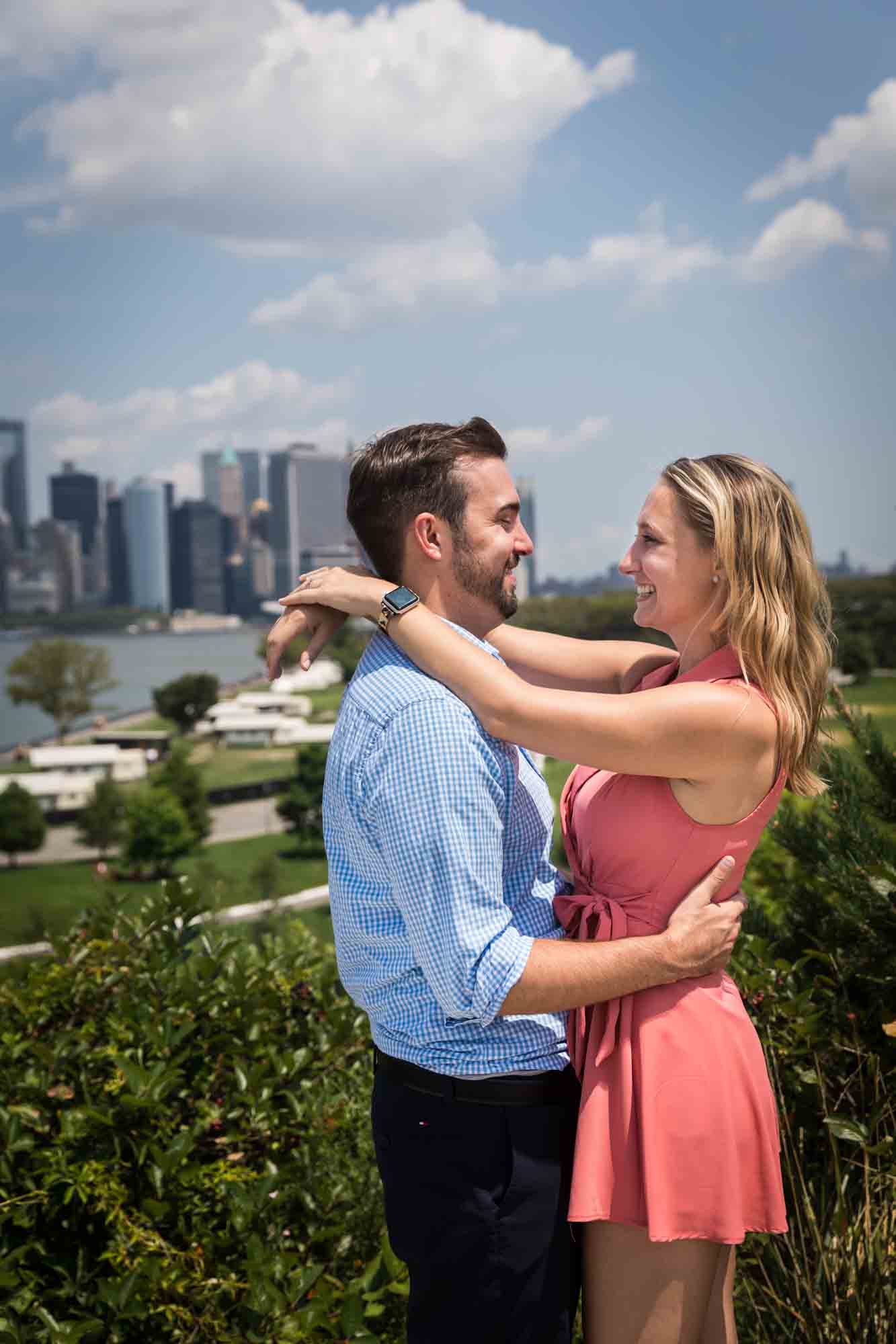 Man and woman hugging on Outlook Hill for an article on how to propose on Governors Island