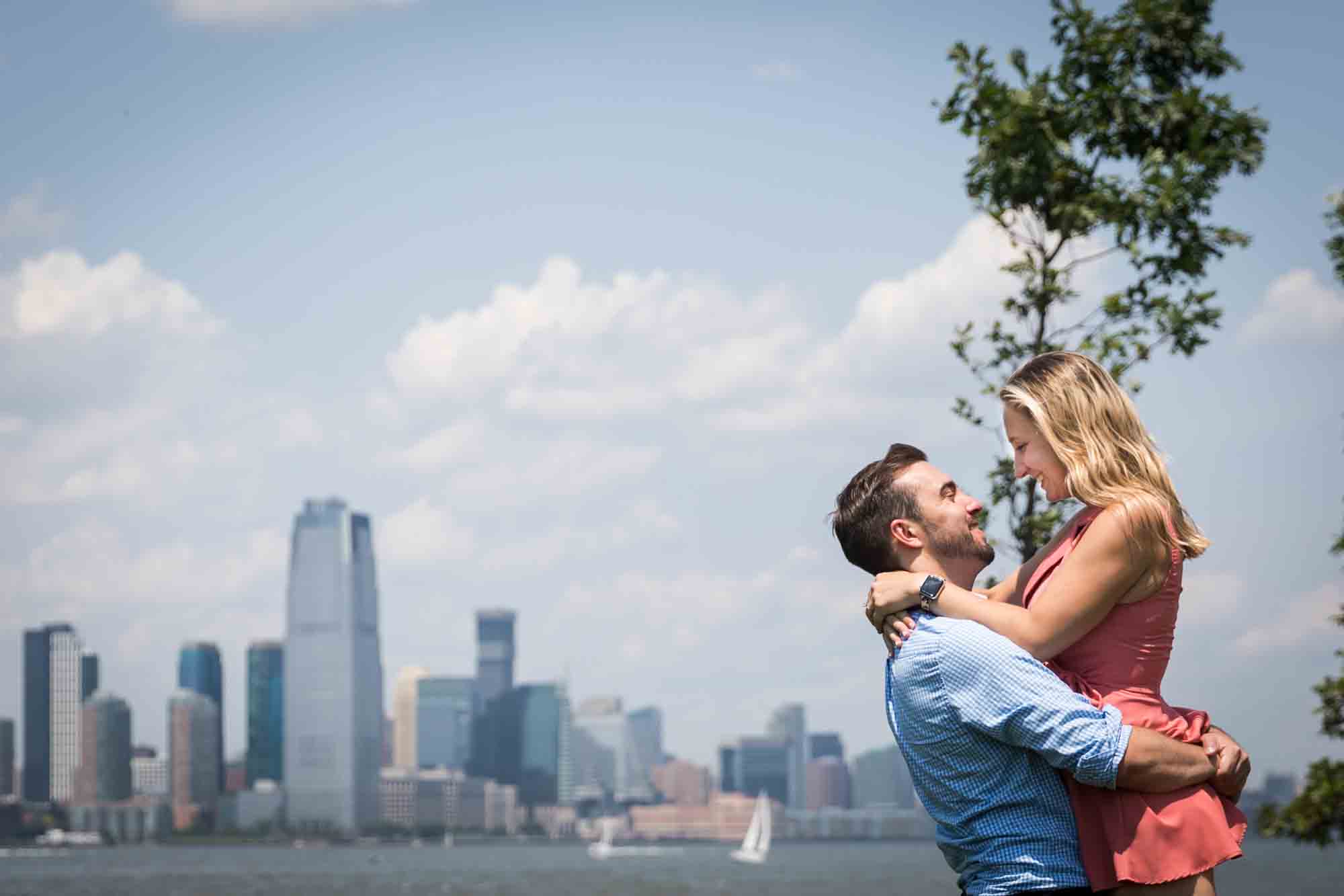 Man lifting up woman on the Play Lawns for an article on how to propose on Governors Island