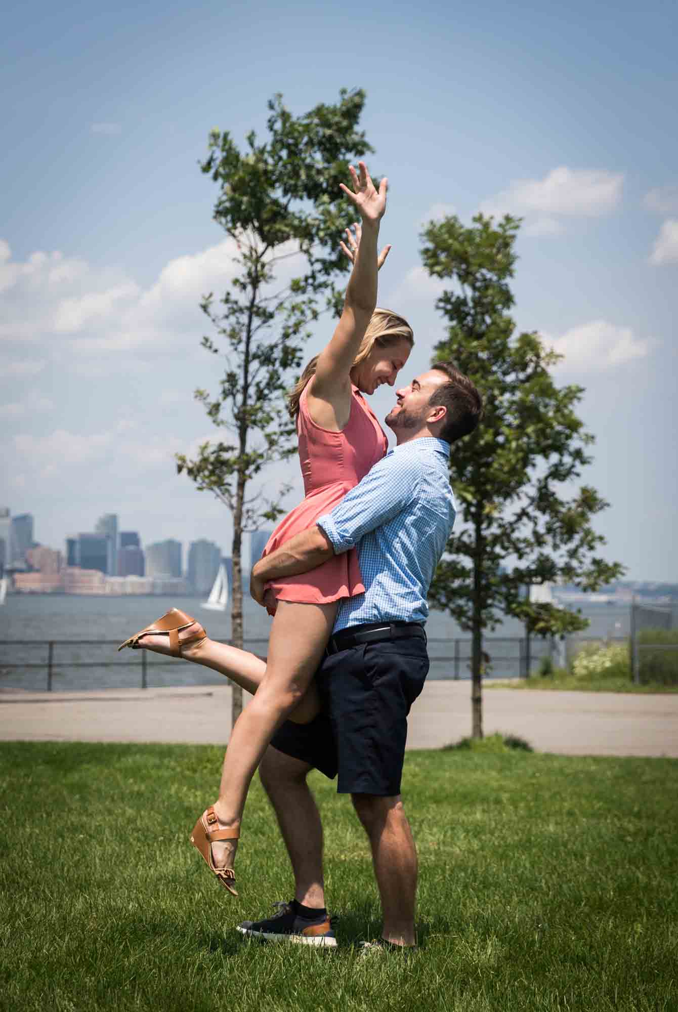 Man lifting up woman on the Play Lawns for an article on how to propose on Governors Island