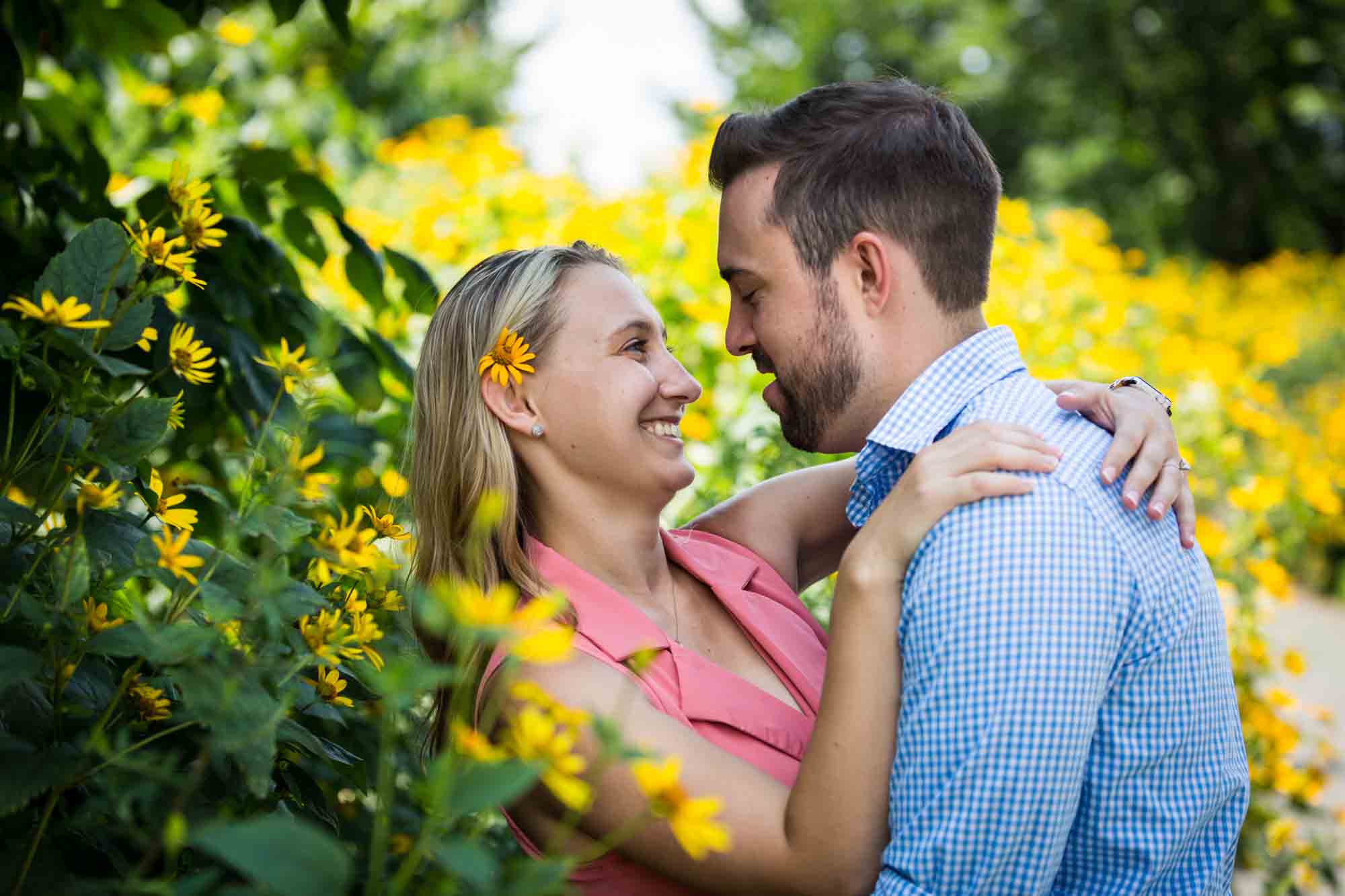 Couple hugging in front of yellow daisies on Governors Island
