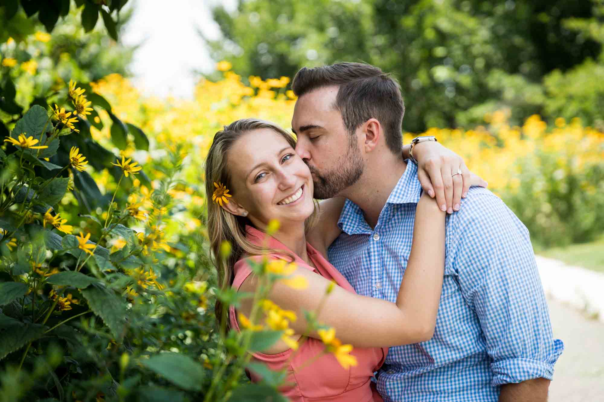 Man kissing woman's cheek in Hammock Grove for an article on how to propose on Governors Island