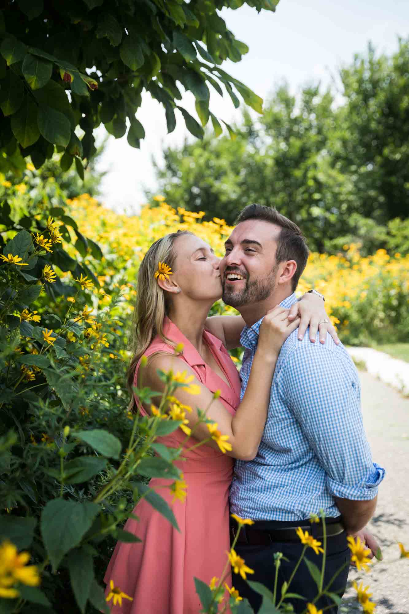 Woman kissing man's cheek in Hammock Grove for an article on how to propose on Governors Island