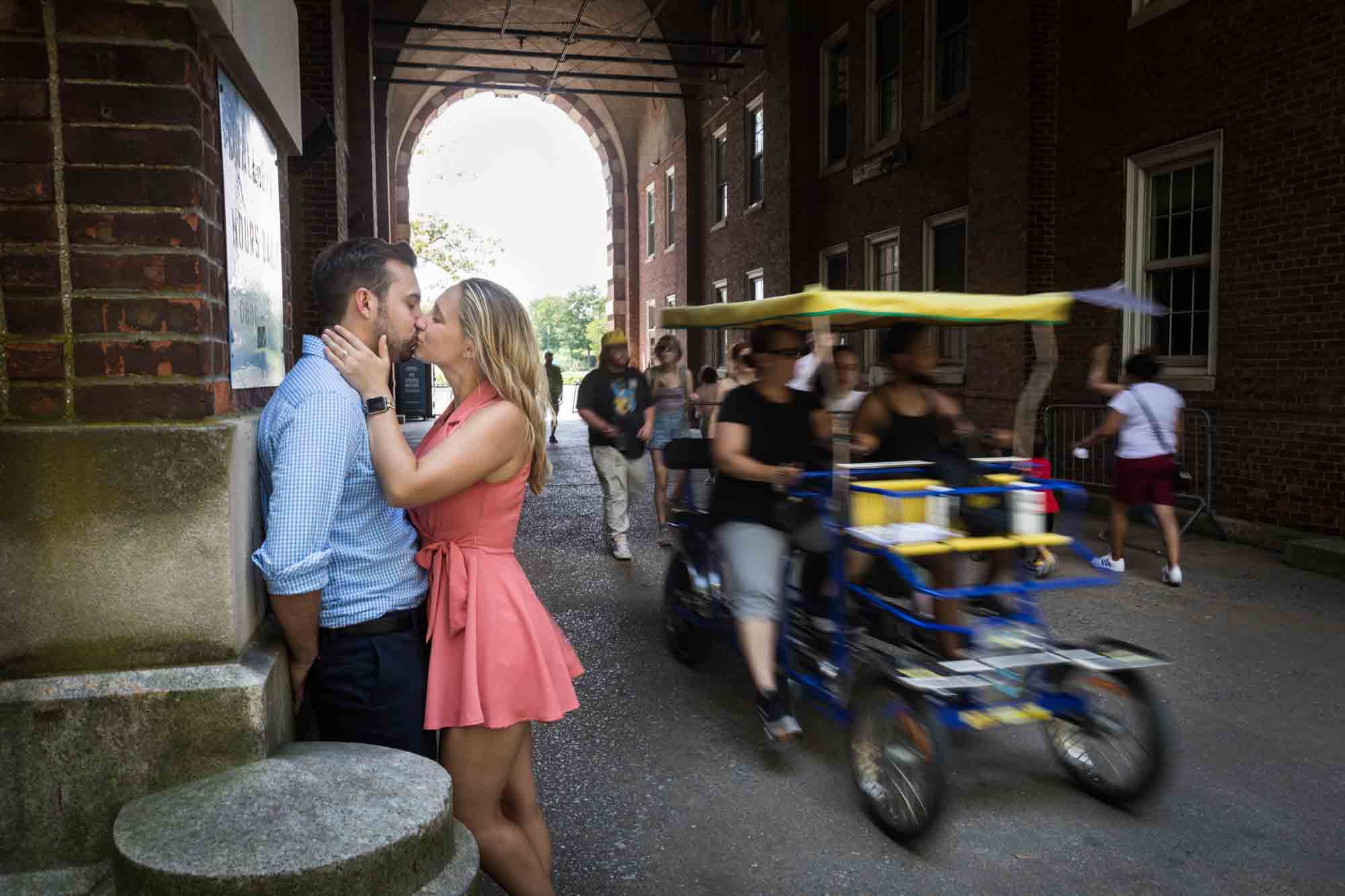 Couple kissing at Liggett Terrace with surrey going past for an article on how to propose on Governors Island