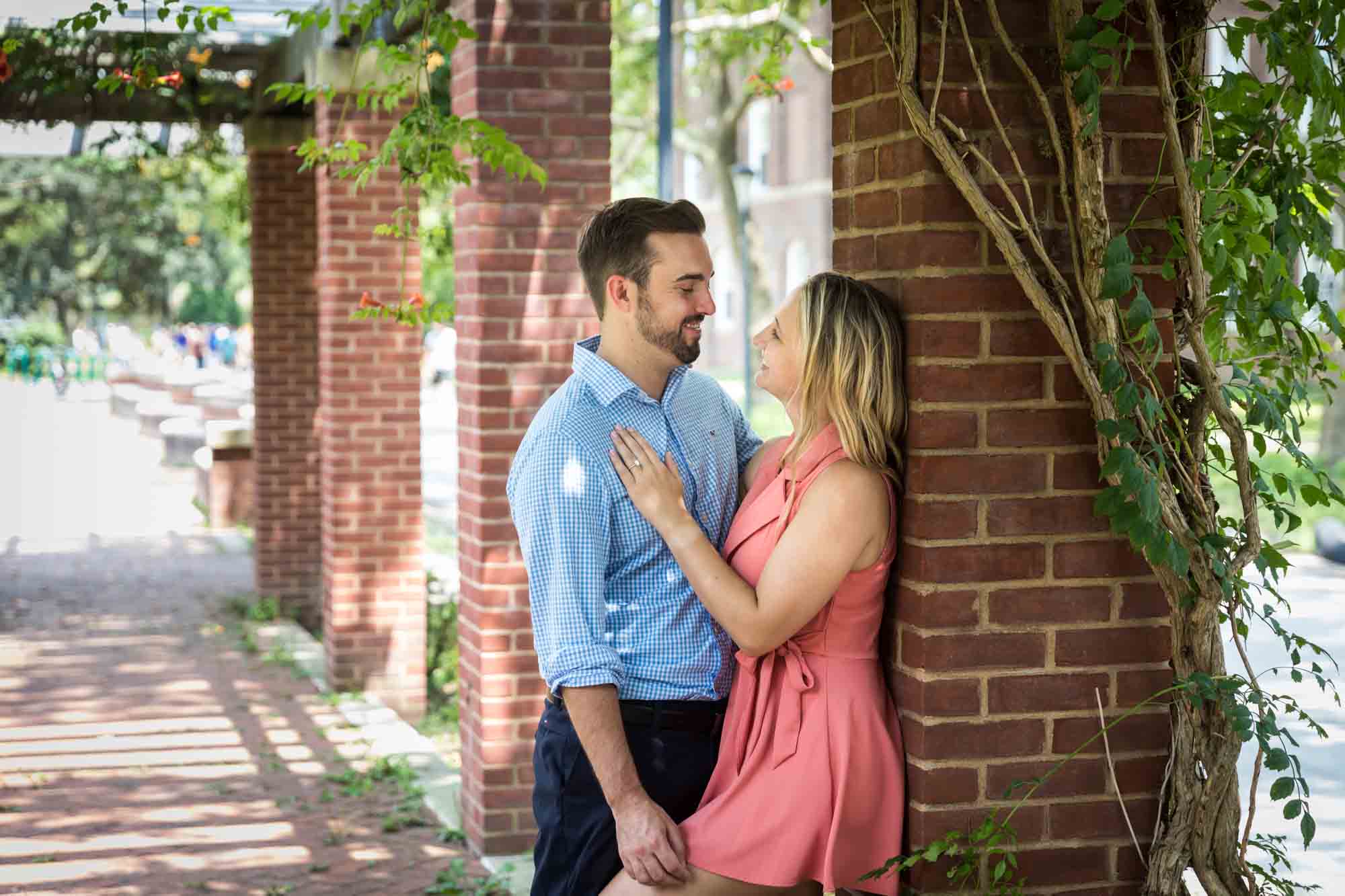 Couple leaning against brick column