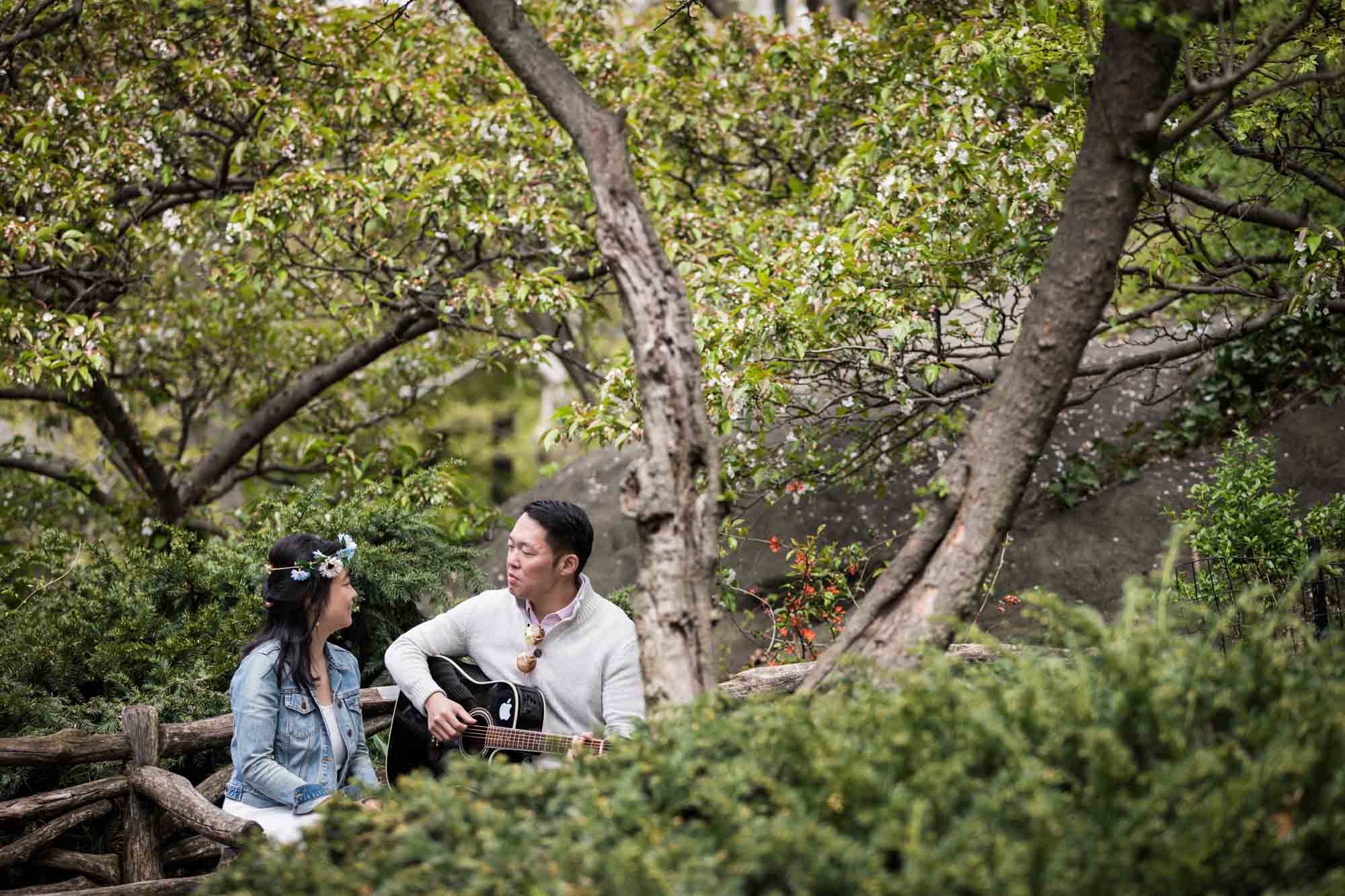 Shakespeare Garden engagement photos of a couple playing guitar in the garden