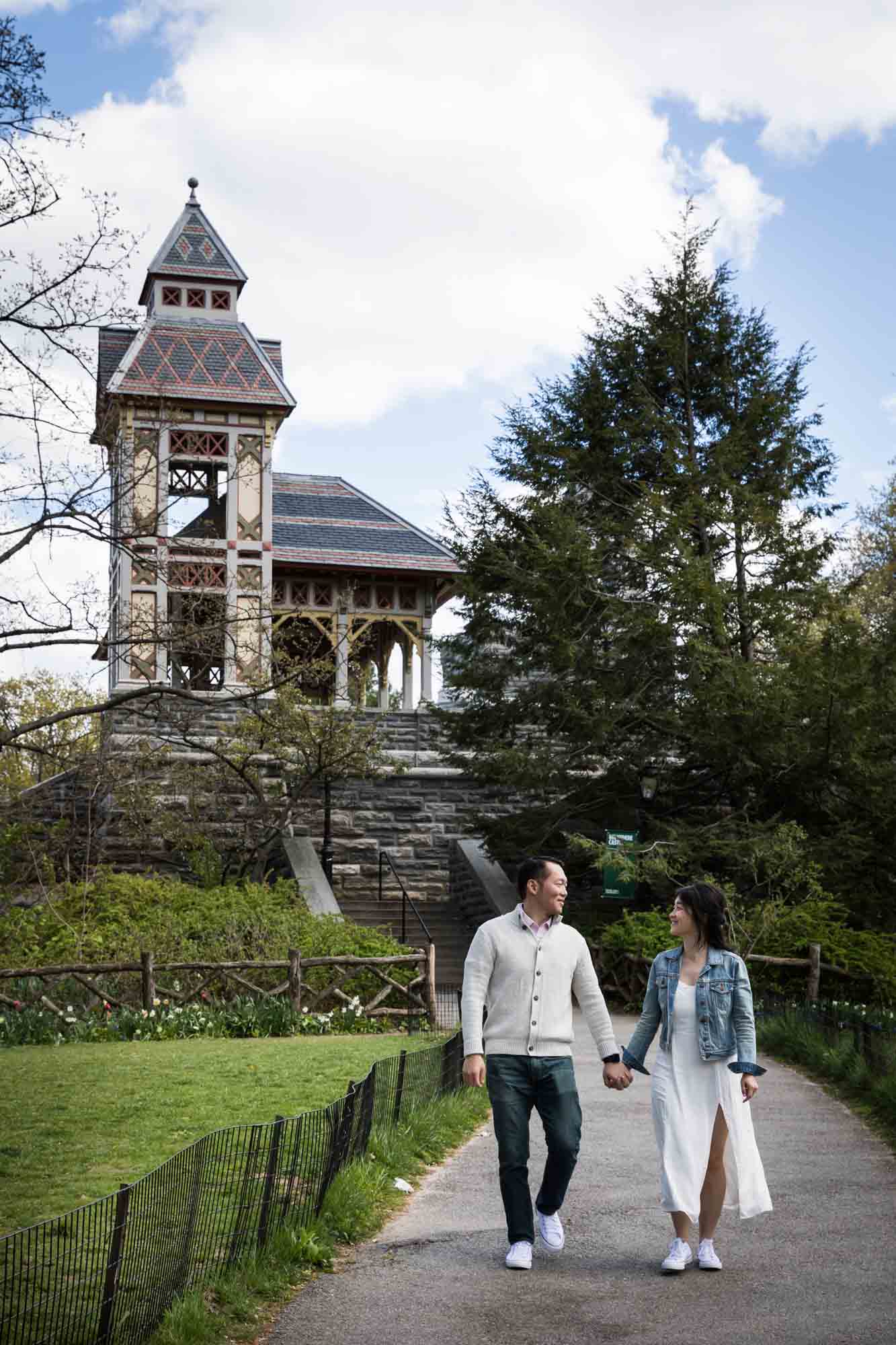 Couple holding hands and walking in front of Belvedere Castle