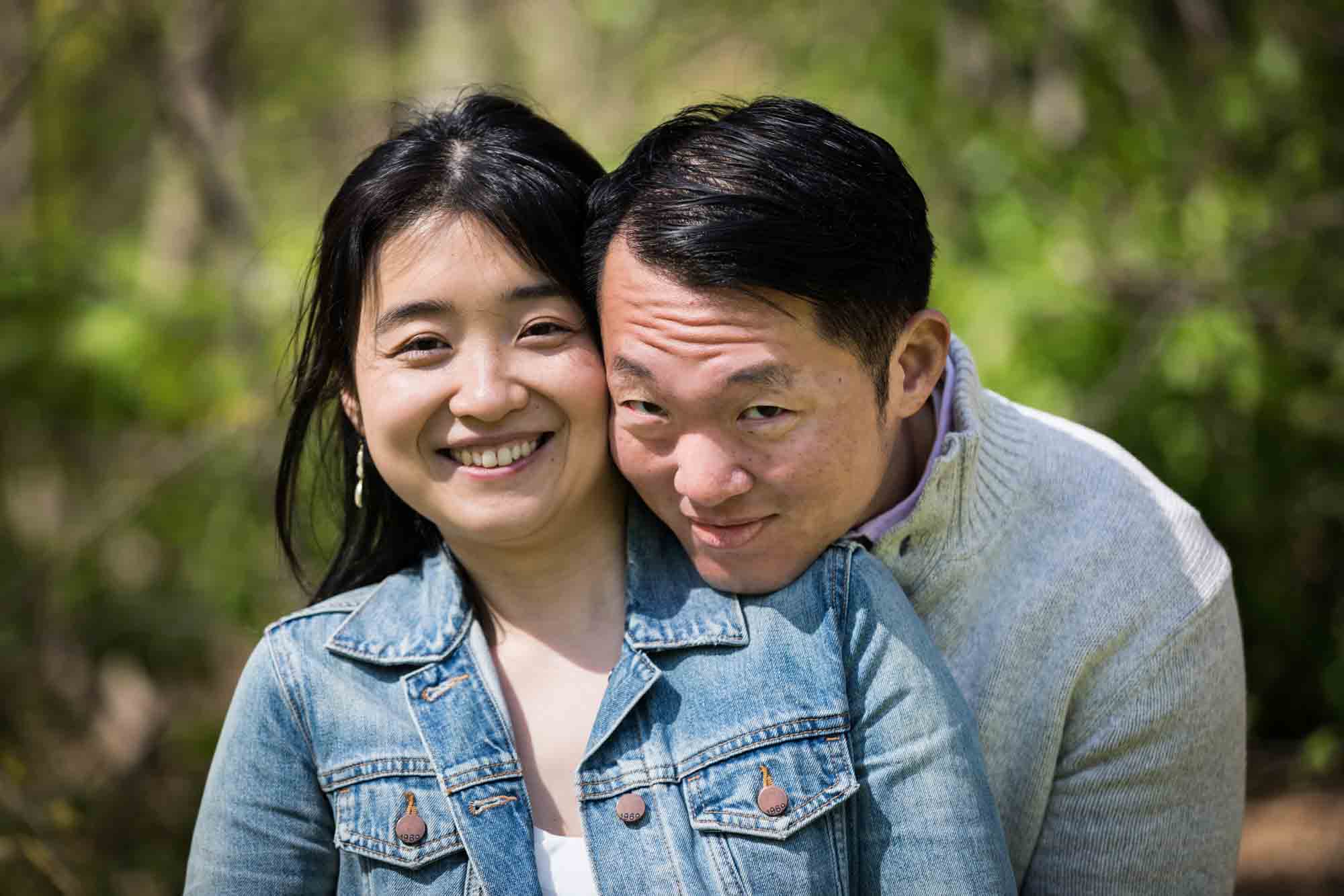 Shakespeare Garden engagement photos of man resting chin on woman's shoulder