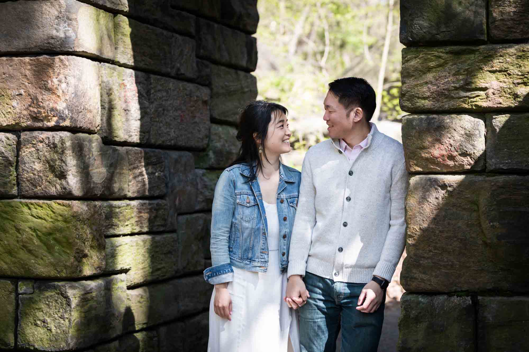 Couple leaning against Stone Arch in Central Park