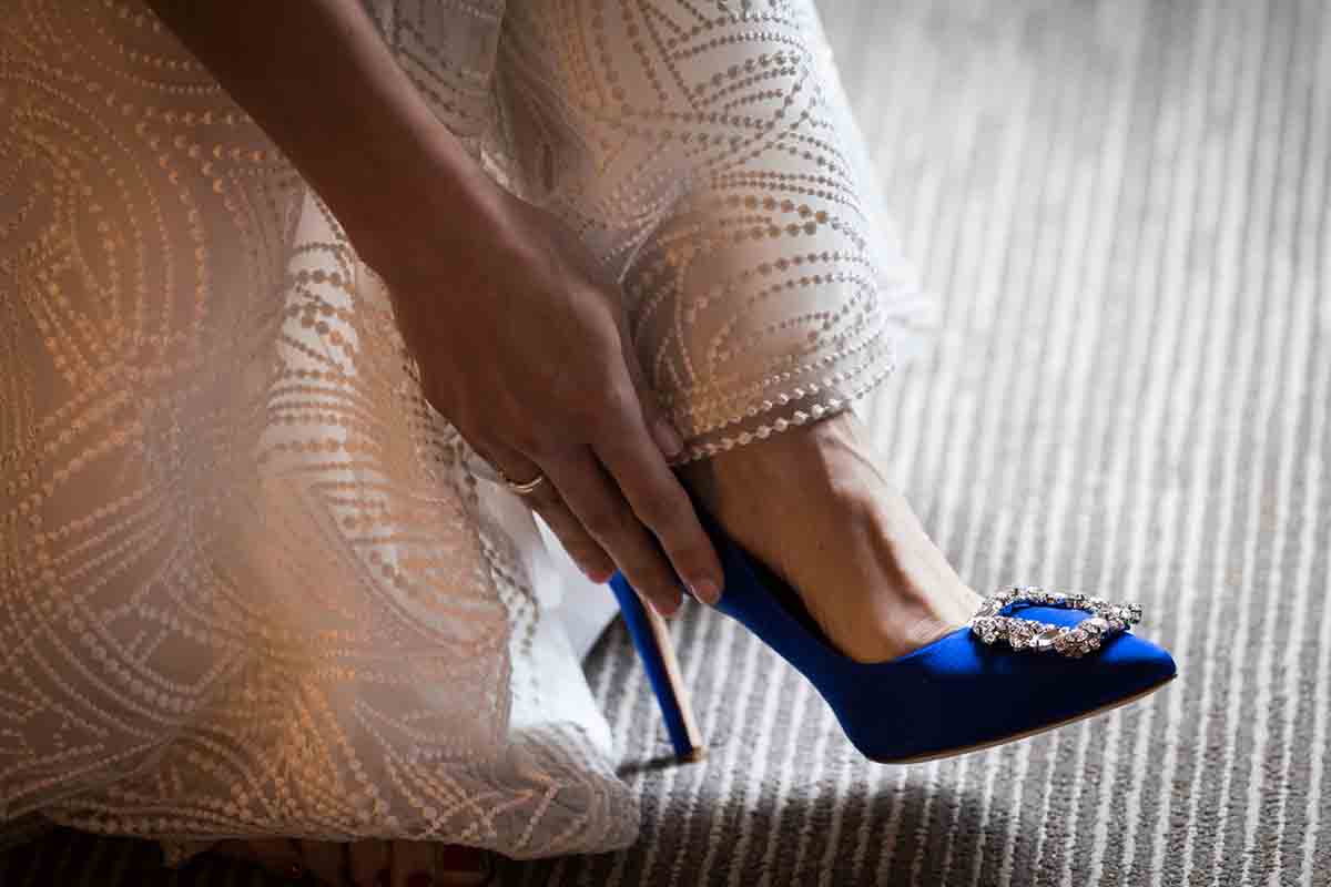 Hand touching blue high heel on foot