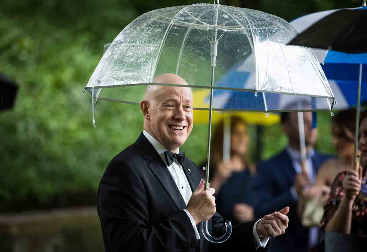 Central Park Wisteria Pergola wedding photos of groom holding clear umbrella