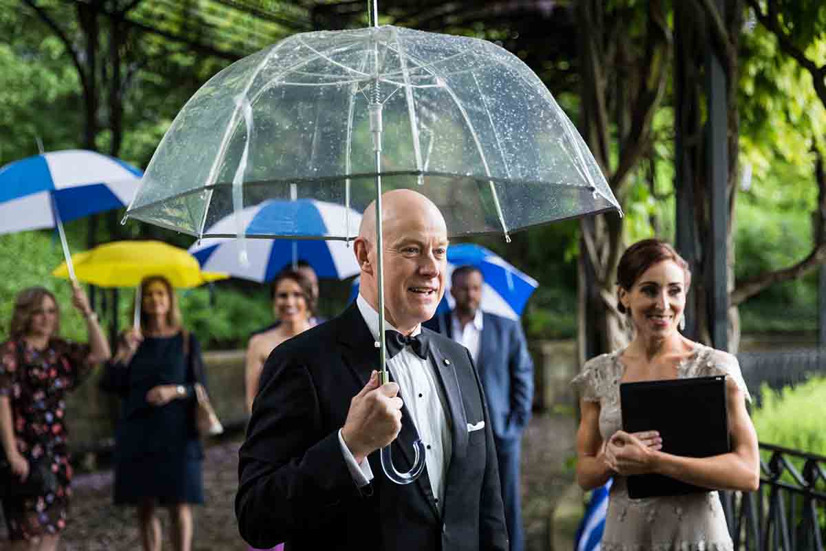 Central Park Wisteria Pergola wedding photos of groom holding umbrella and seeing bride for the first time