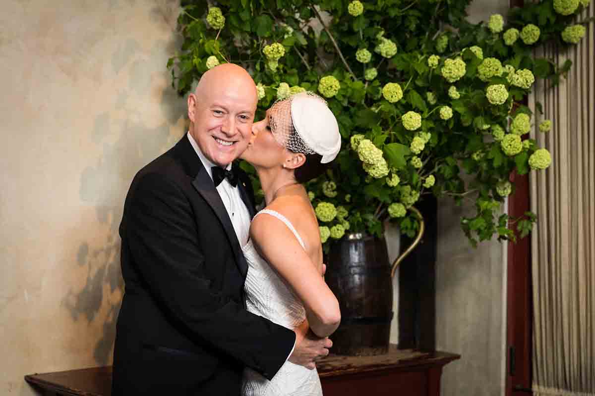 Central Park Wisteria Pergola wedding photos of bride kissing groom on the cheek