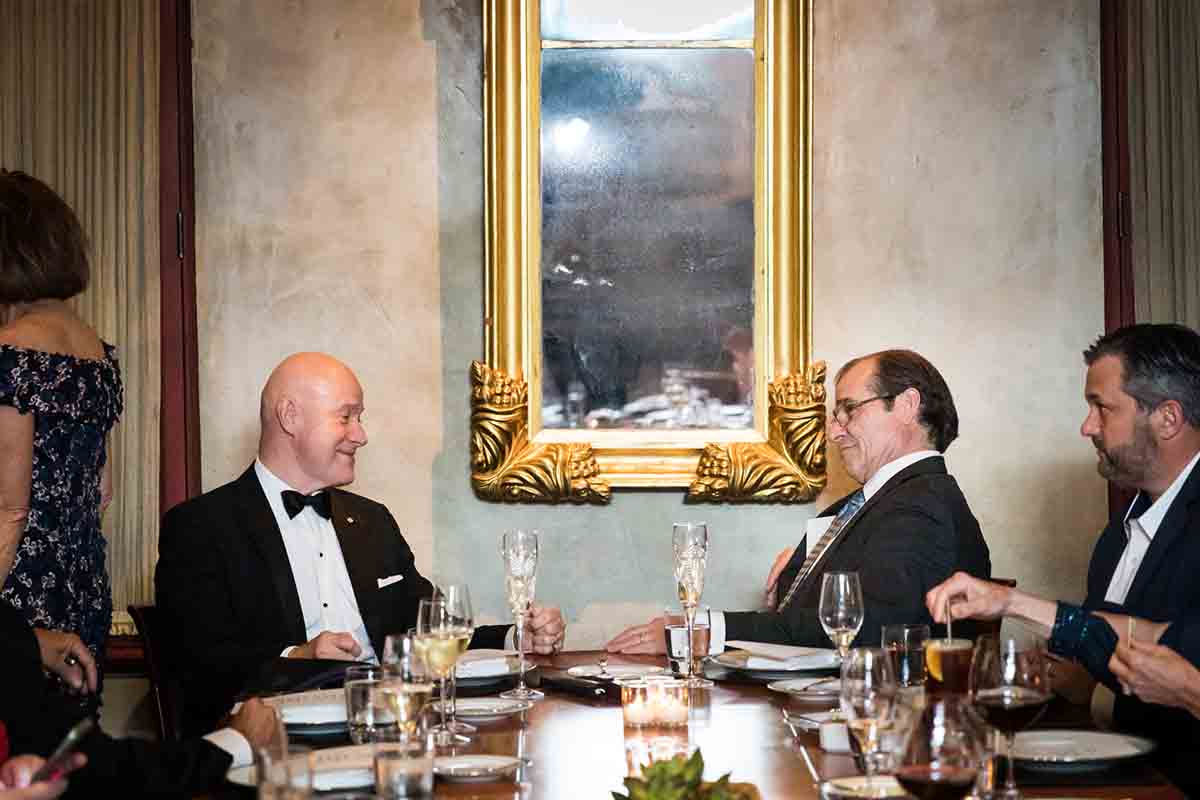 Gramercy Tavern wedding reception photos of groom speaking with male guest at a table