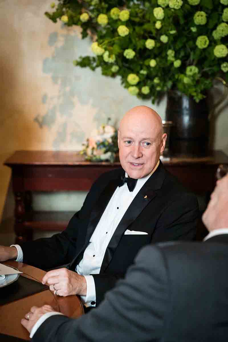 Gramercy Tavern wedding reception photos of groom wearing a tuxedo while sitting at a table