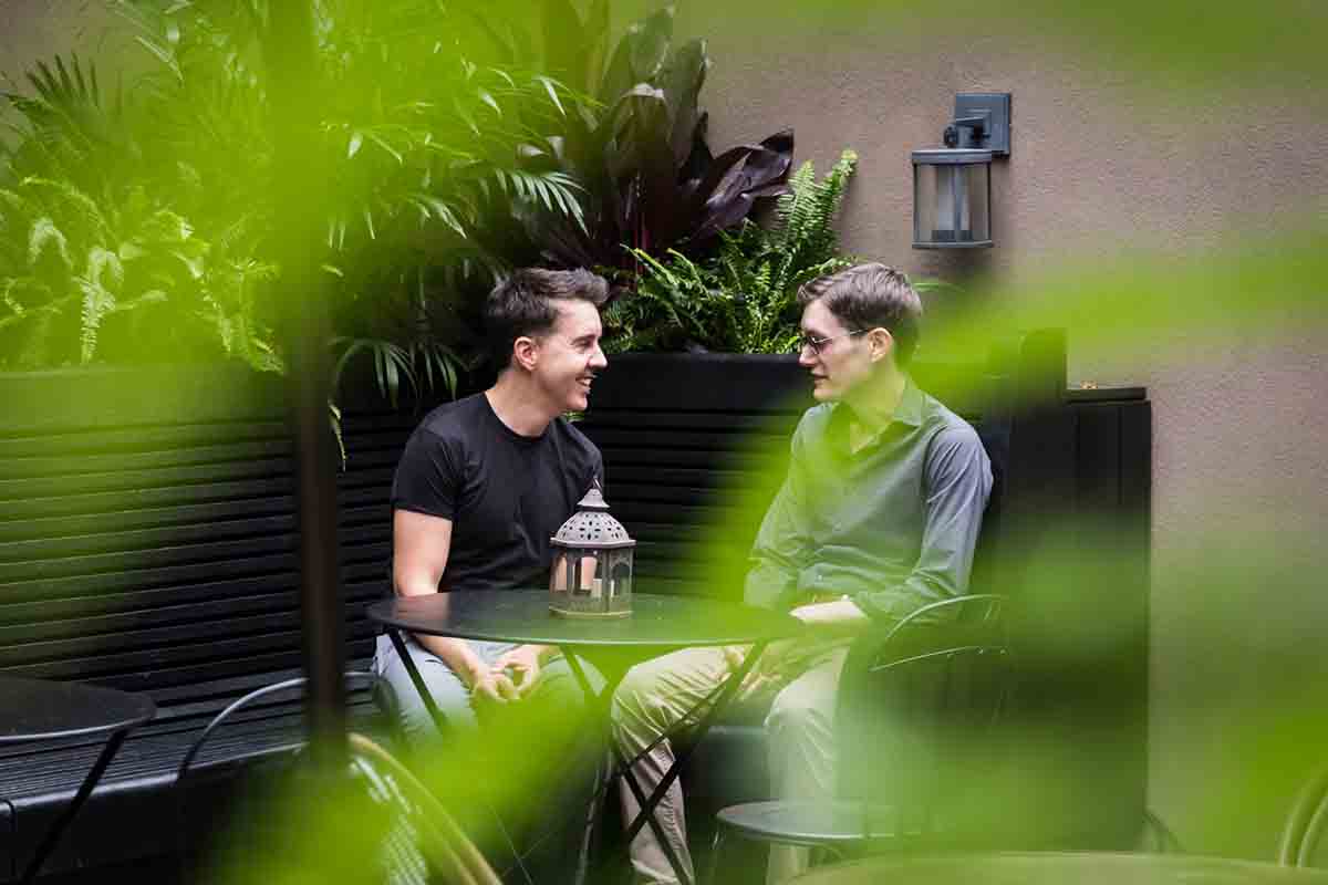 Two men sitting at an outdoor table at the High Line Hotel