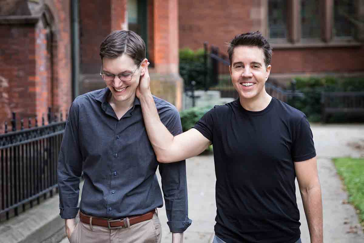 Man touching the cheek of another man while walking along the pathway