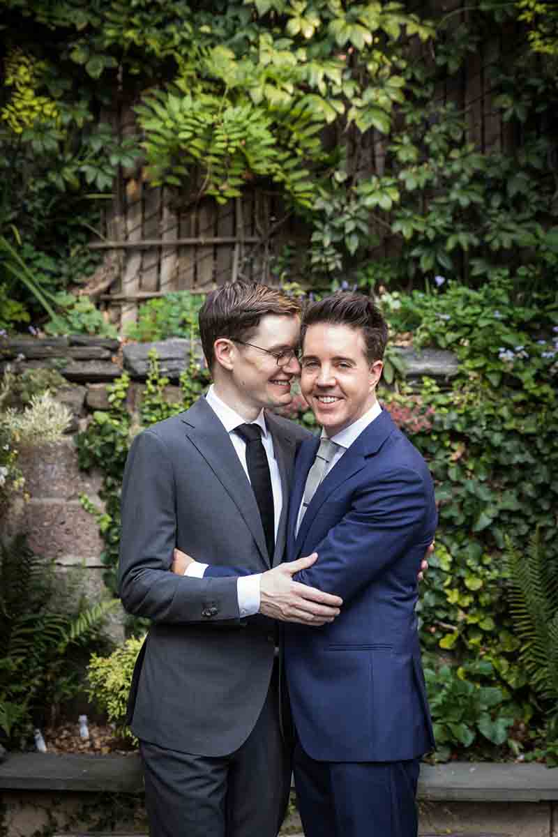 Merchant’s House Museum NYC wedding photos of two grooms in front of vine-covered wall