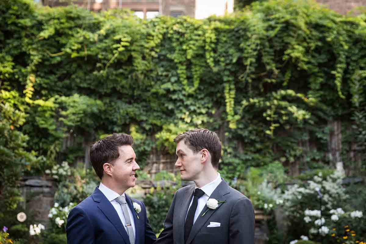 Merchant’s House Museum NYC wedding photos of two grooms in front of vine-covered wall