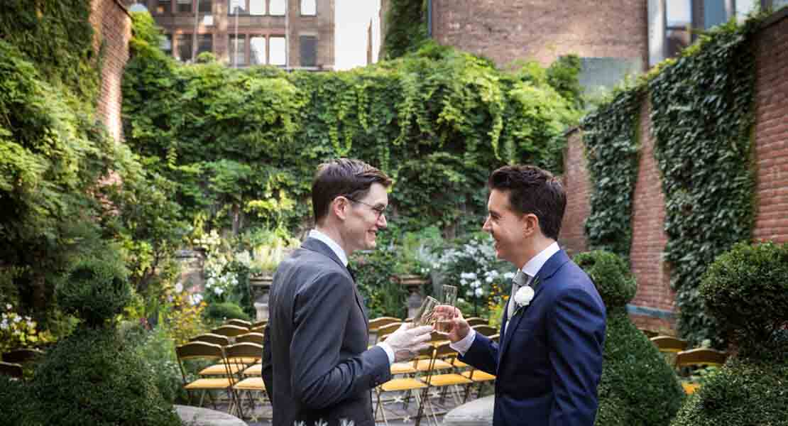 Merchant’s House Museum NYC wedding photos of two grooms toasting champagne glasses