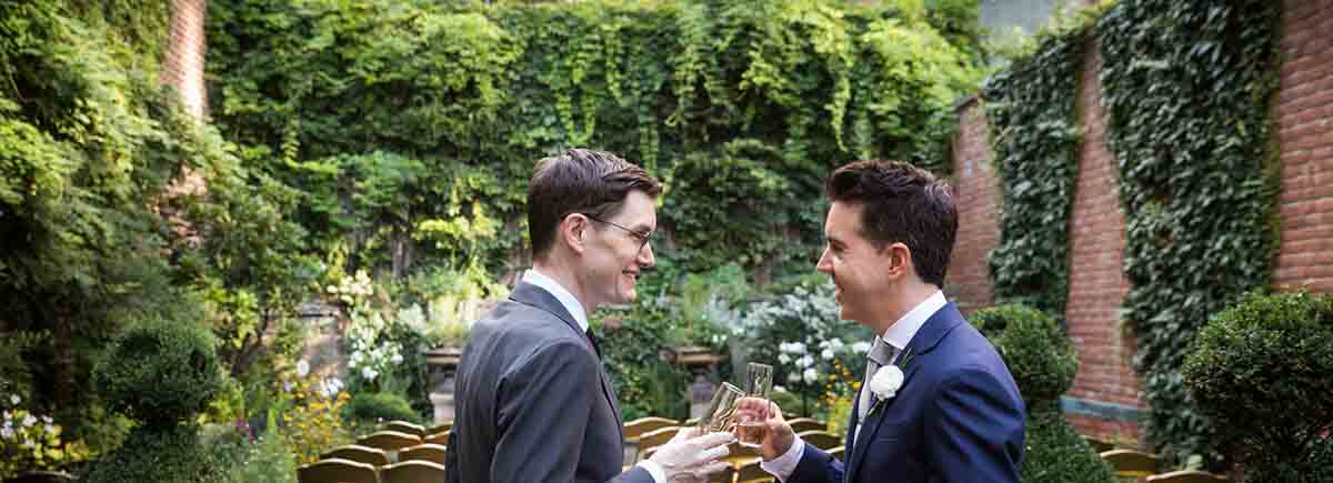 Merchant’s House Museum NYC wedding photos of two grooms toasting champagne glasses