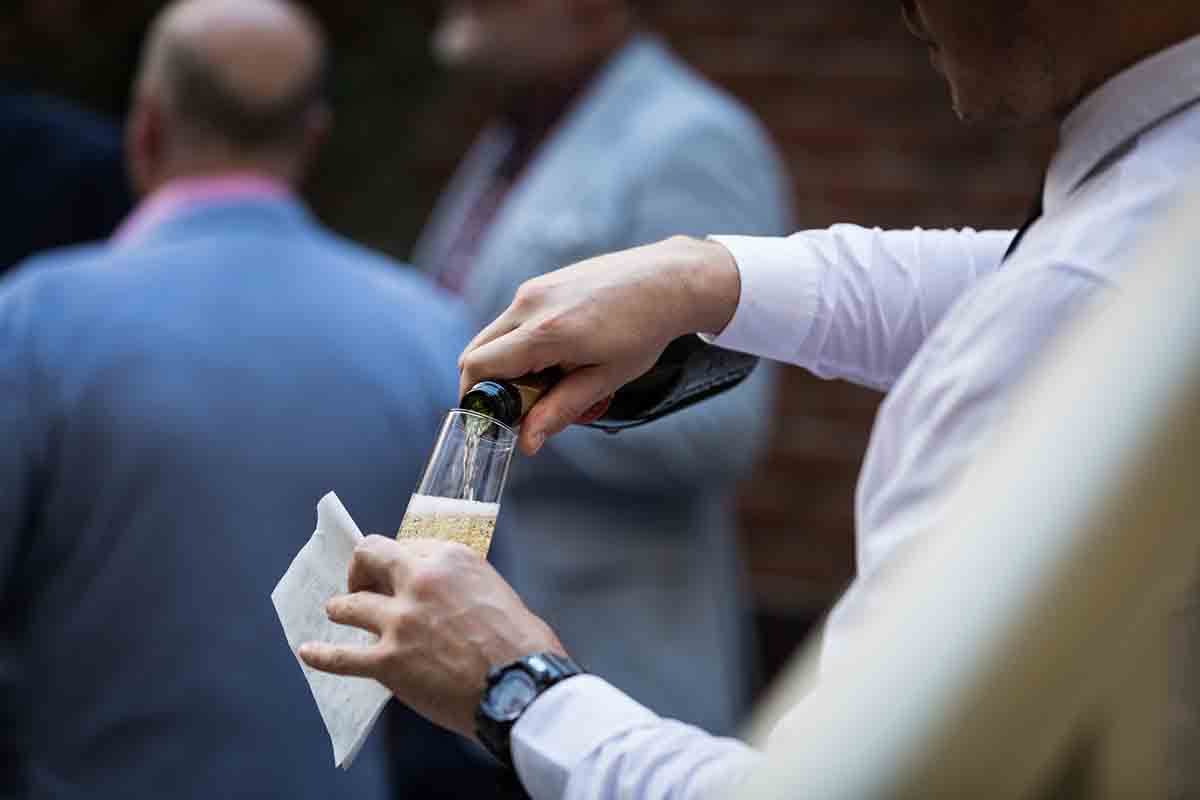 Close up of bartender pouring a glass of champagne