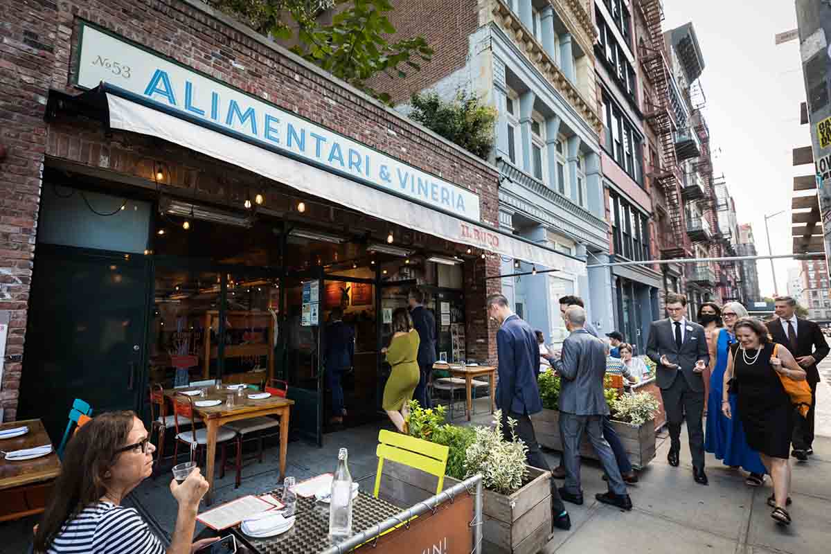 Guests walking on sidewalk into Il Alimentari wedding reception