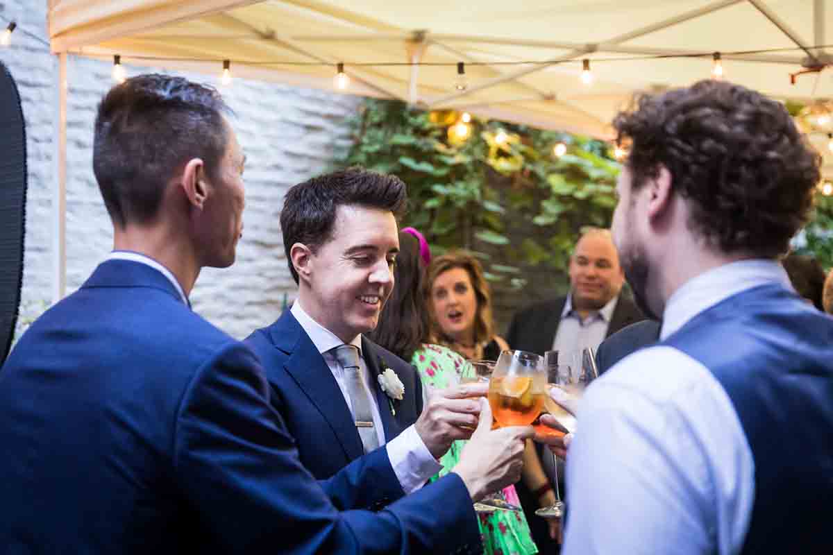 Groom toasting glasses with guests during wedding Il Buco Alimentari and Vineria wedding reception