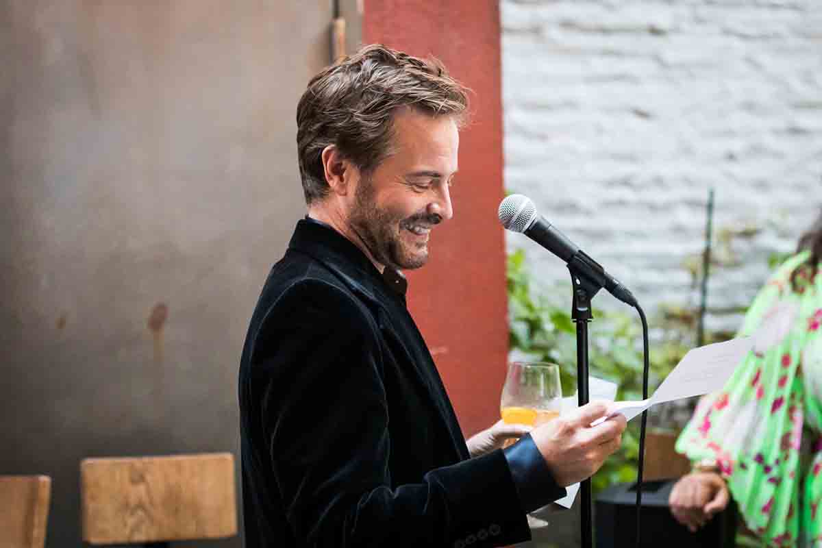 Male guest giving speech with microphone during wedding Il Buco Alimentari and Vineria wedding reception