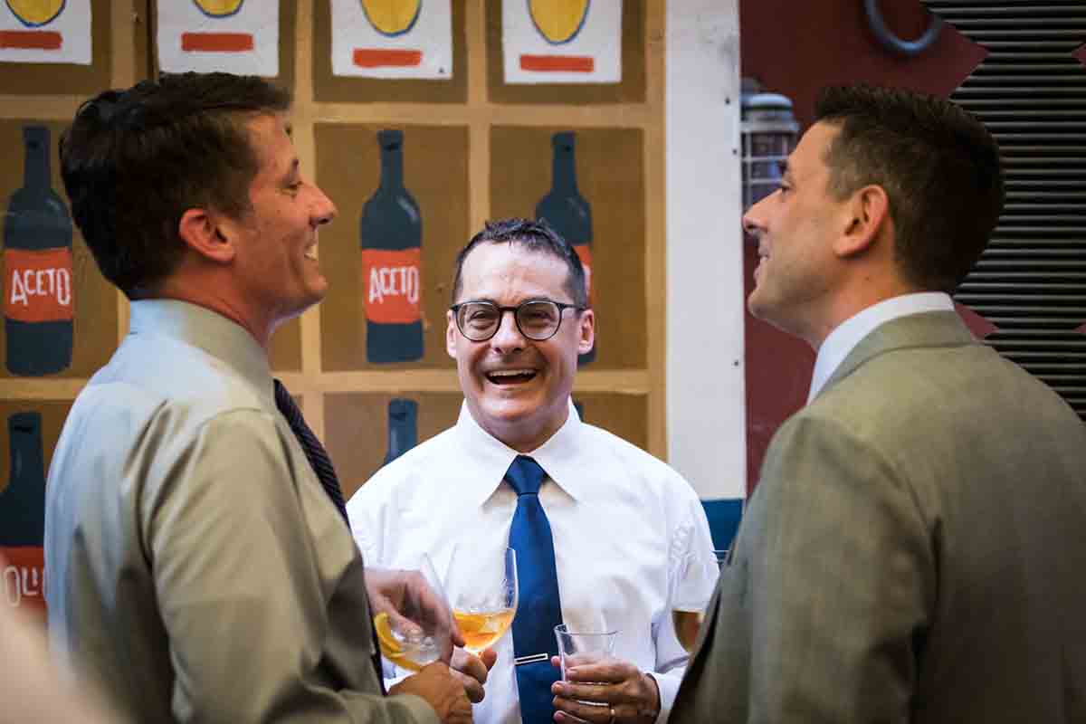 Three male guests chatting during wedding Il Buco Alimentari and Vineria wedding reception