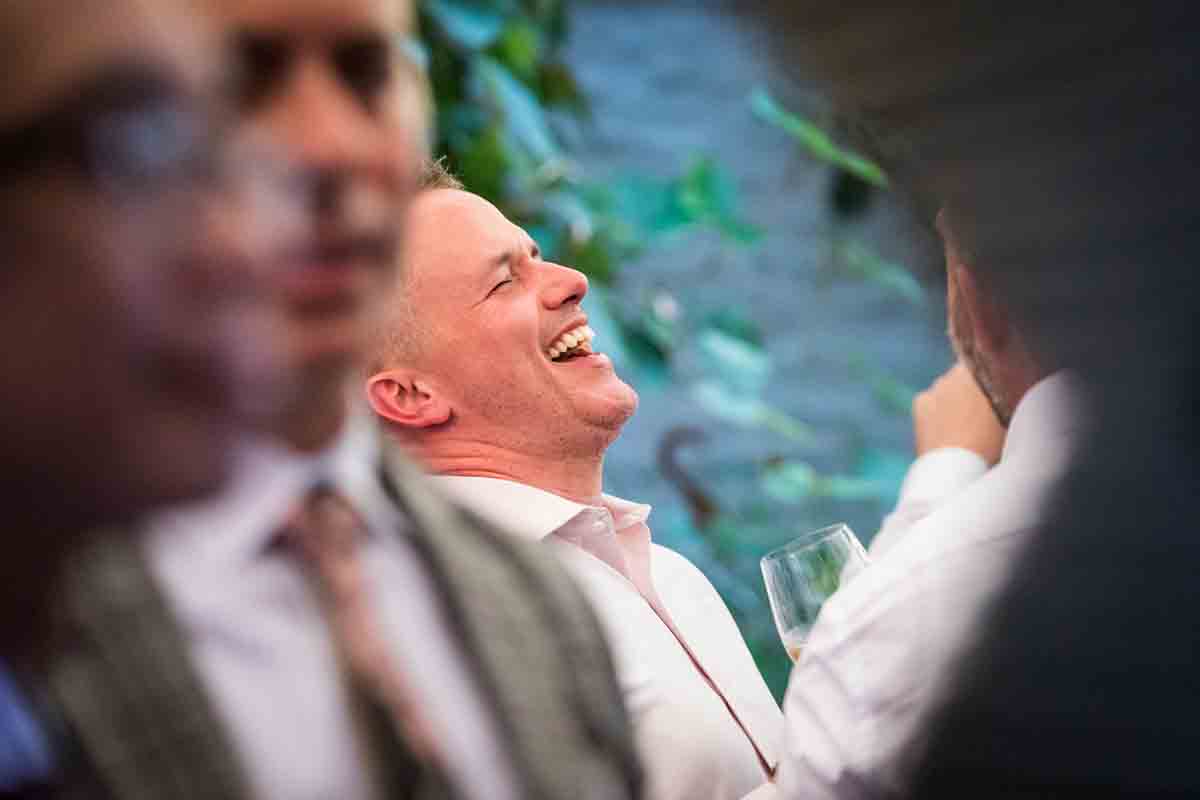 Male guest laughing during wedding Il Buco Alimentari and Vineria wedding reception