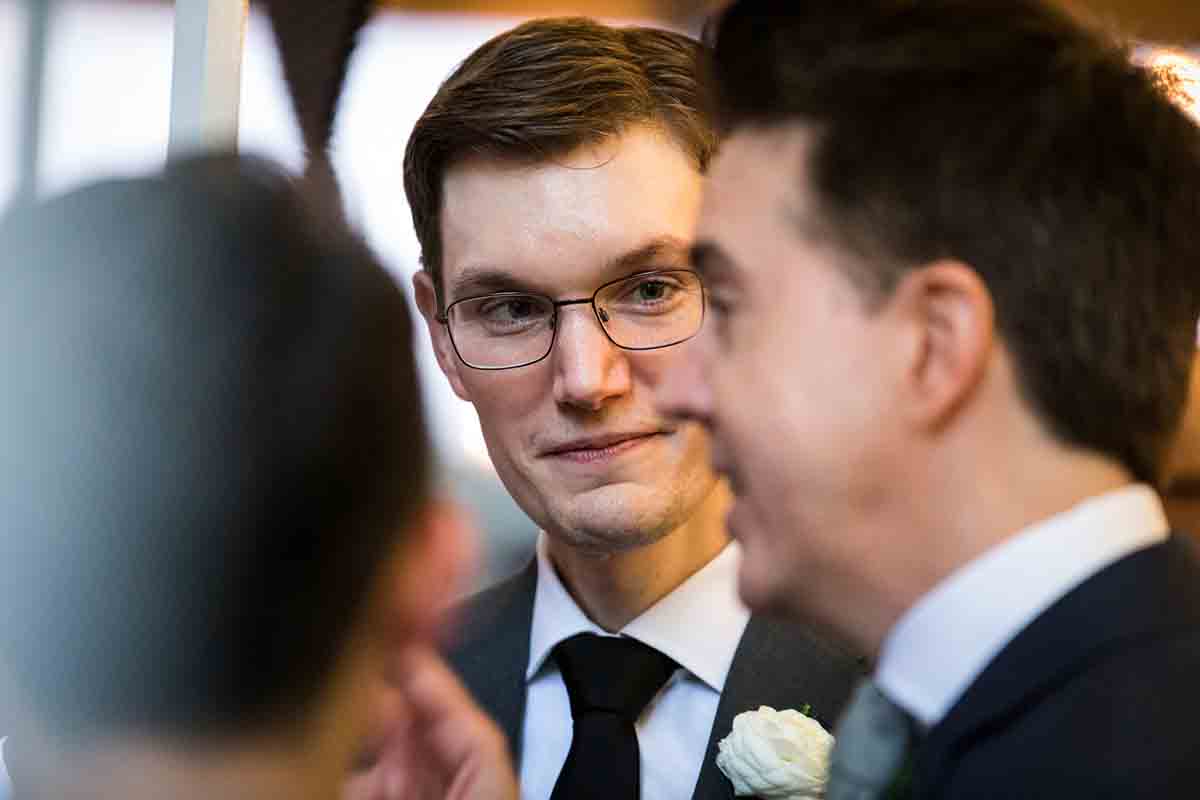 Groom listening to guests during wedding Il Buco Alimentari and Vineria wedding reception